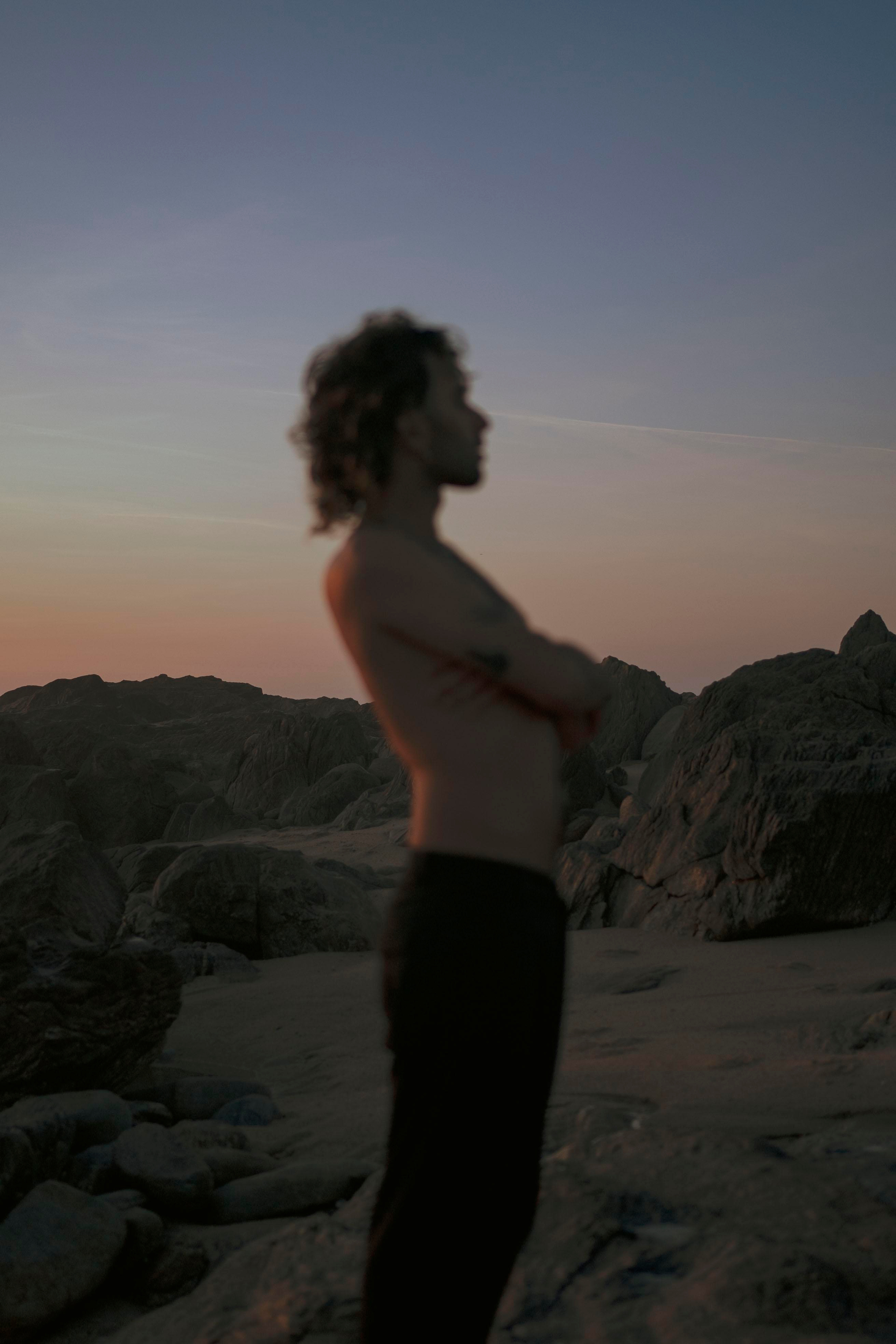 Silhouette of a person with a sunset sky in the background.