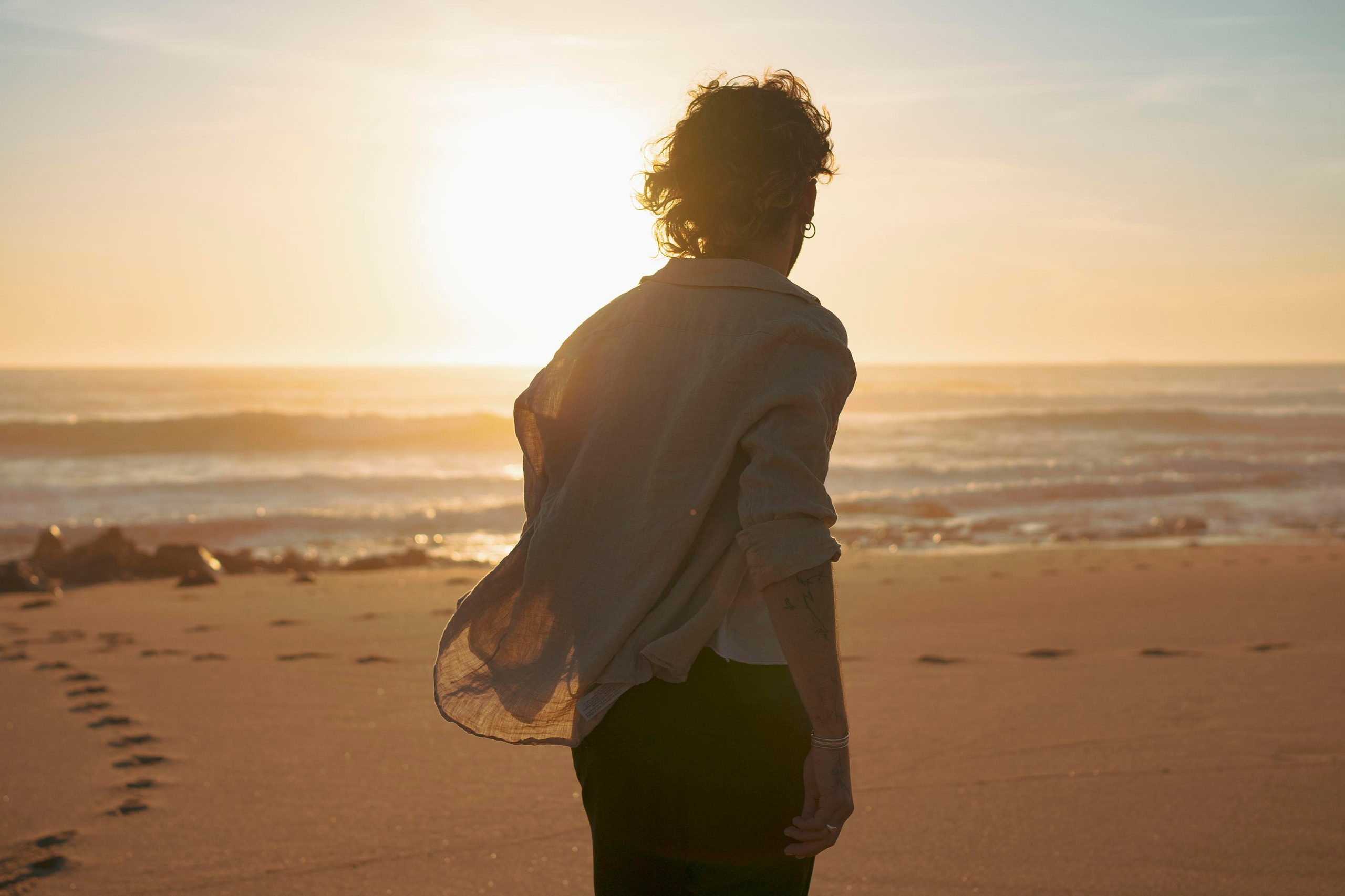 Silhouette of a person with a sunset sky in the background.