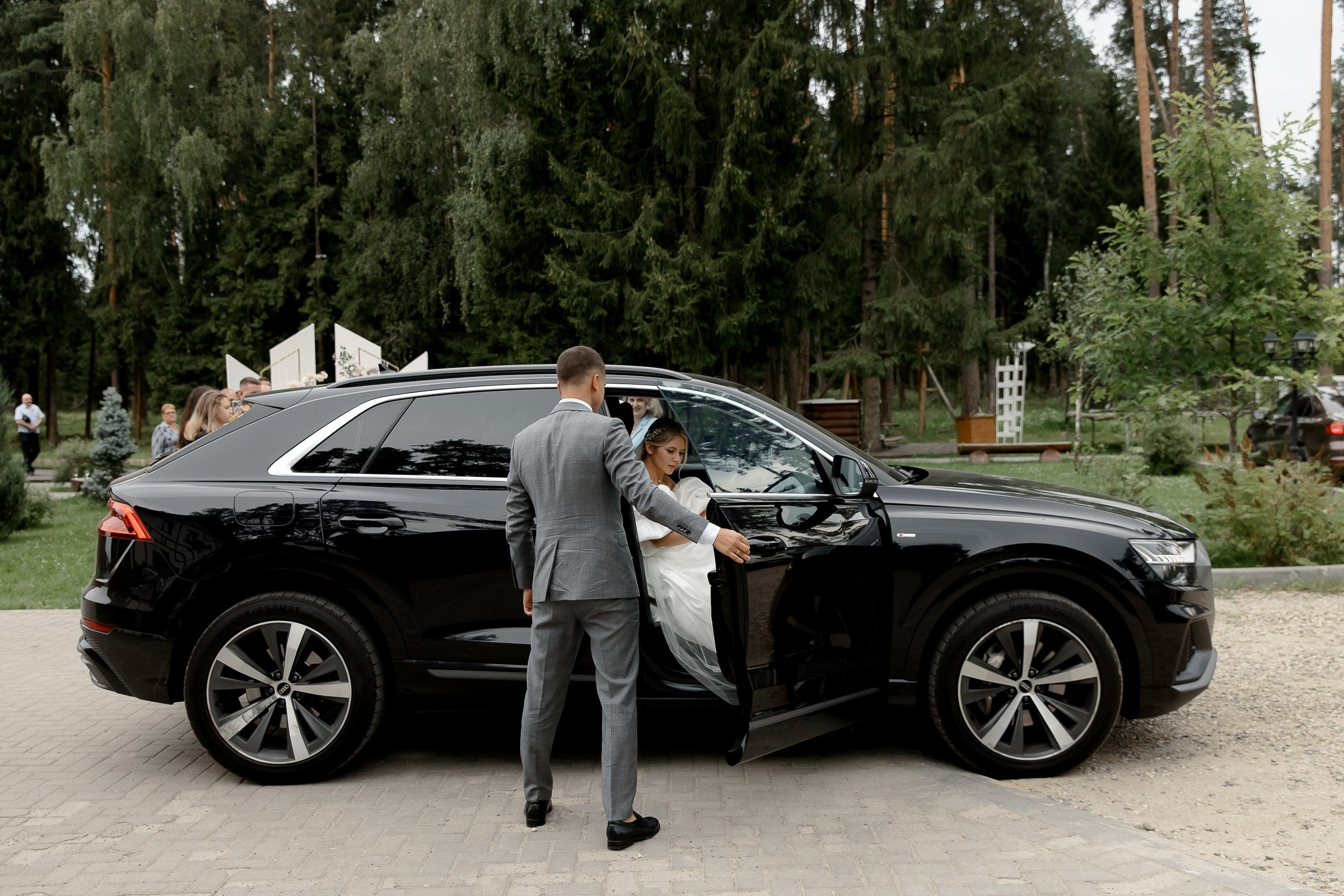 Groom opening car door for bride, by Bude, Cornwall wedding photographer.