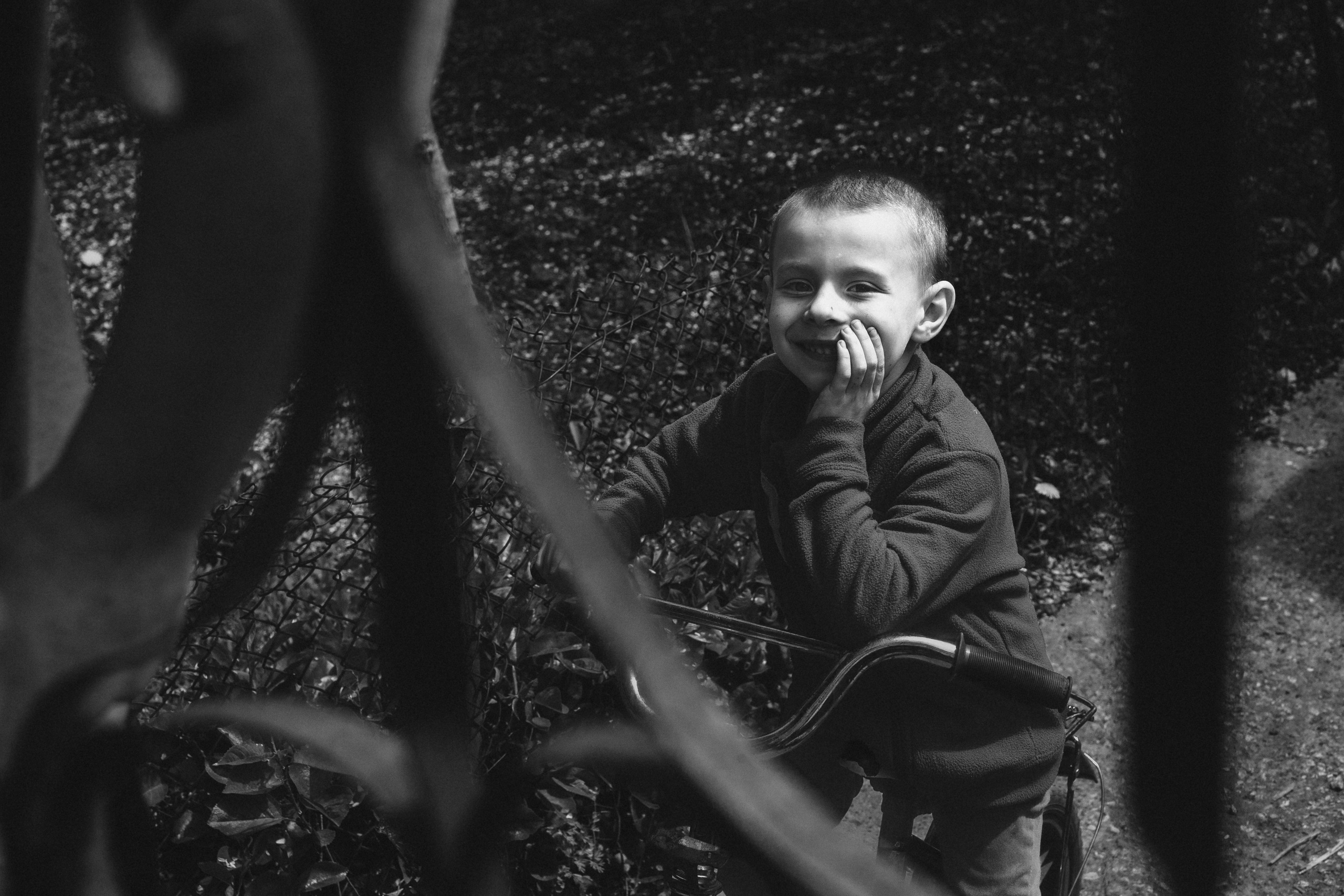 чёрно-белая социальная документальная фотография портрет бедность мальчик забор улыбка Фотограф в Ирландии