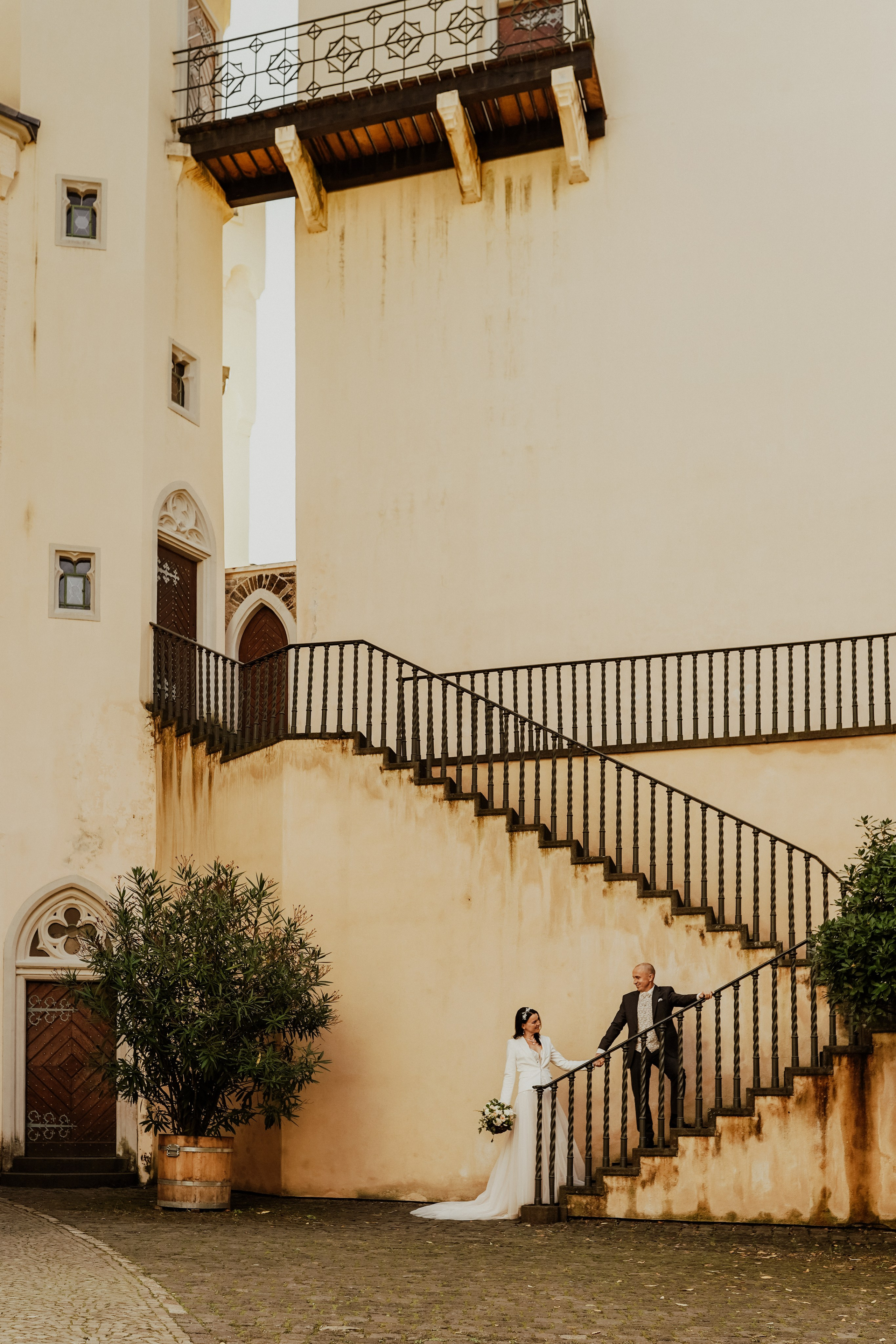 Zauberhaftes Brautpaar vor einem historischen Schloss, das den Zauber des Hochzeitstages verstärkt