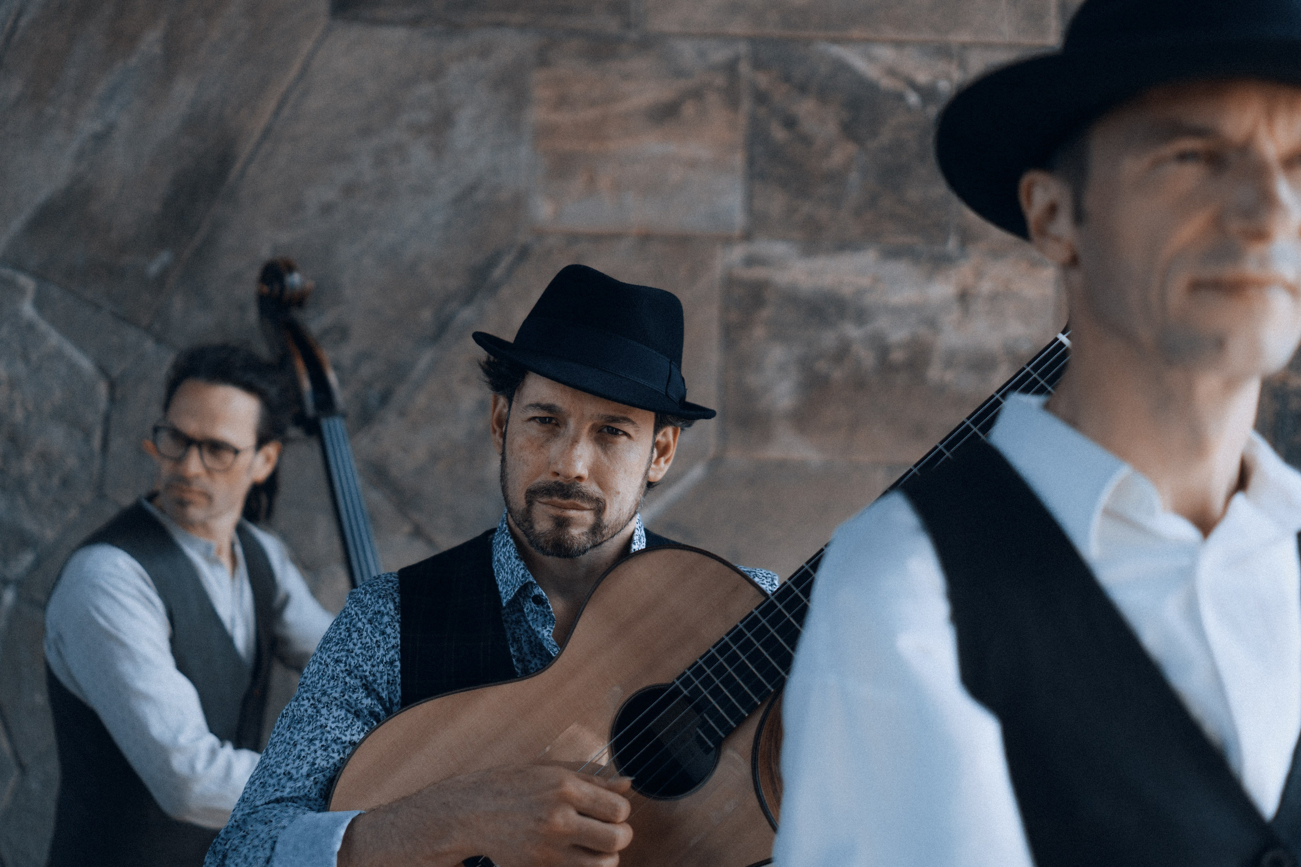 Gitarrist im Vordergrund, andere Bandmitglieder unscharf dahinter