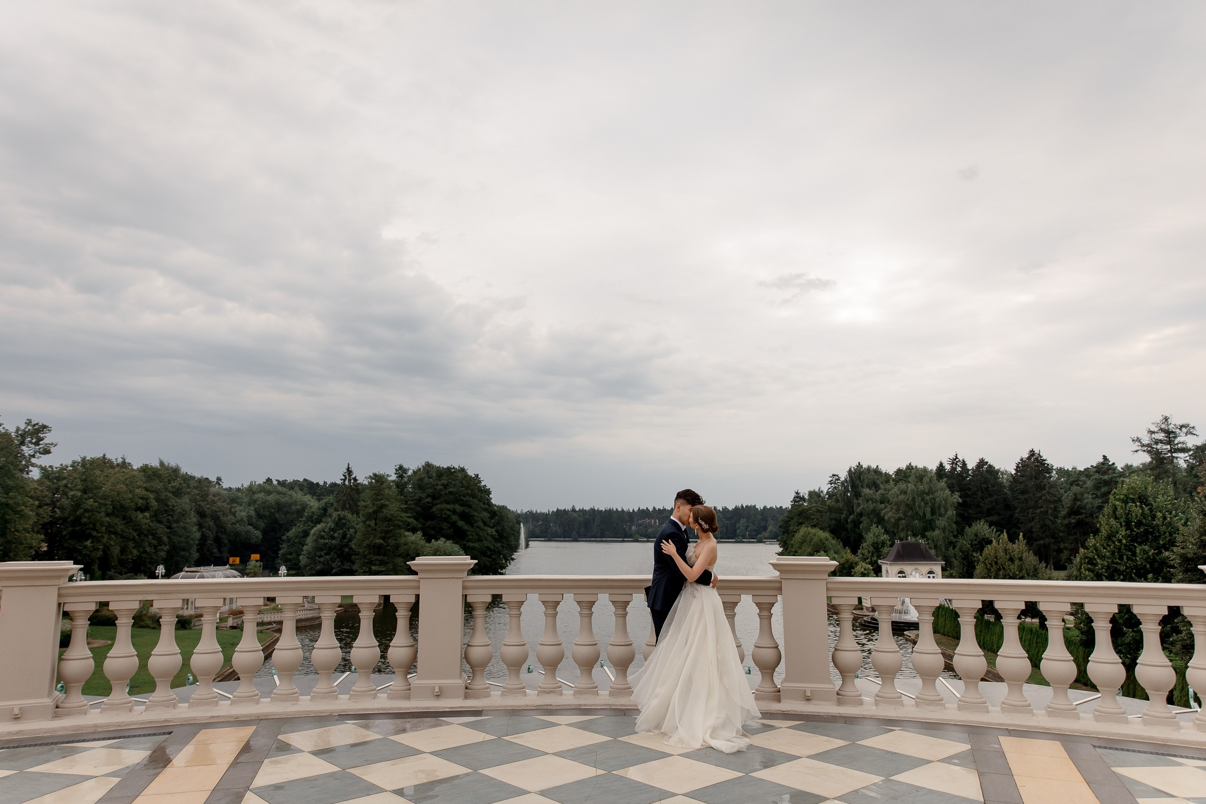Bride and groom embrace at balcony, by Cornwall editorial photographer.
