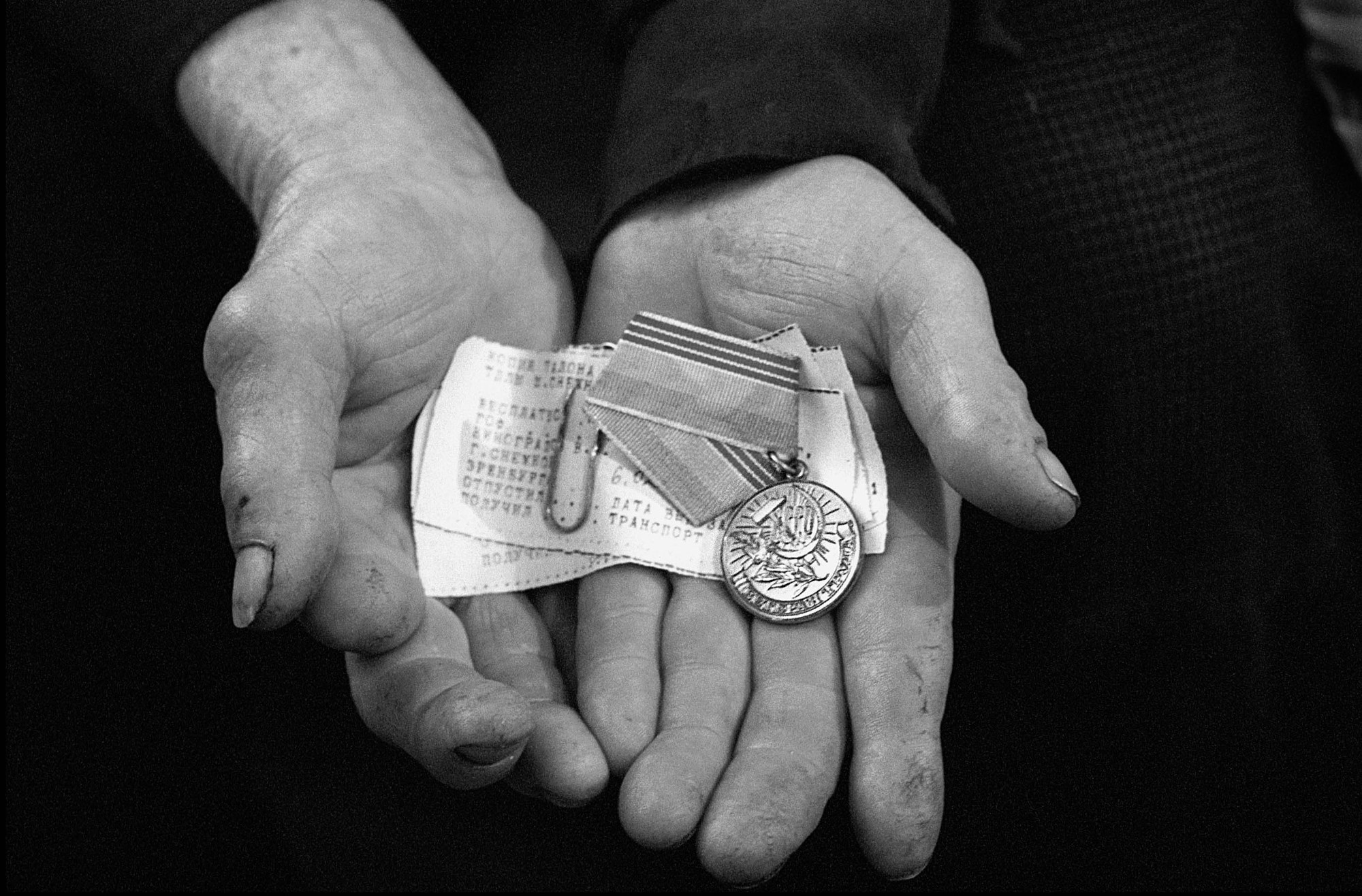 Valentine, 64, proudly shows his medal and pension slips for 30 years of service at his home February 25, 2002 near Snezhnoye, Ukraine. Valentine considers himself lucky for receiving 50 Gryvnyas (nearly $8.50) a month. He gives half of his pension to his son to ensure that his granddaughter will have enough to eat. Valentine feels that the Ukrainian government has abandoned them because they are ethnic Russians.