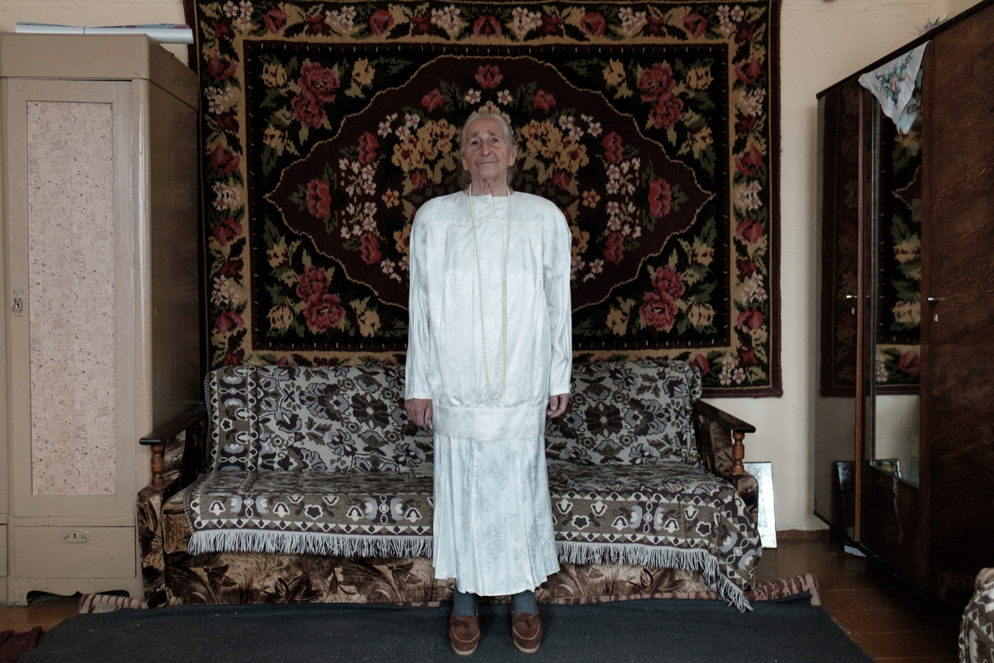 Vera is standing in a wedding dress of her daughter. 