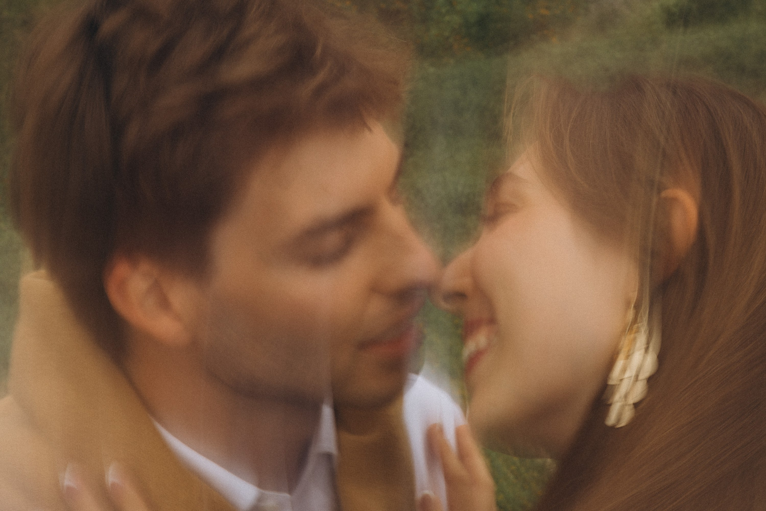 Beautiful engagement moment by the ocean in Madeira, Portugal, as one partner kneels to propose while waves crash in the background