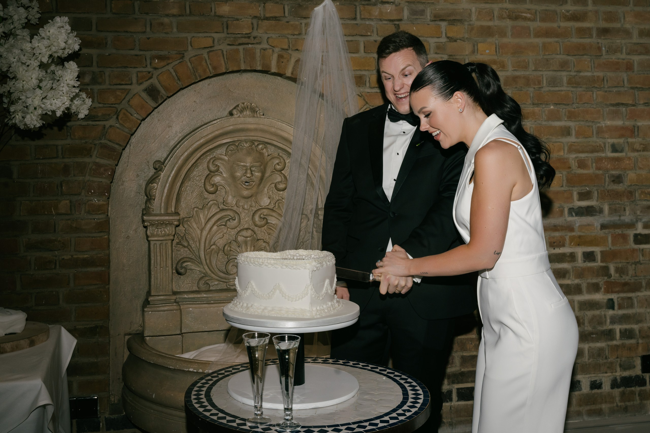 Bride and groom cutting the wedding cake at Friern Manor reception