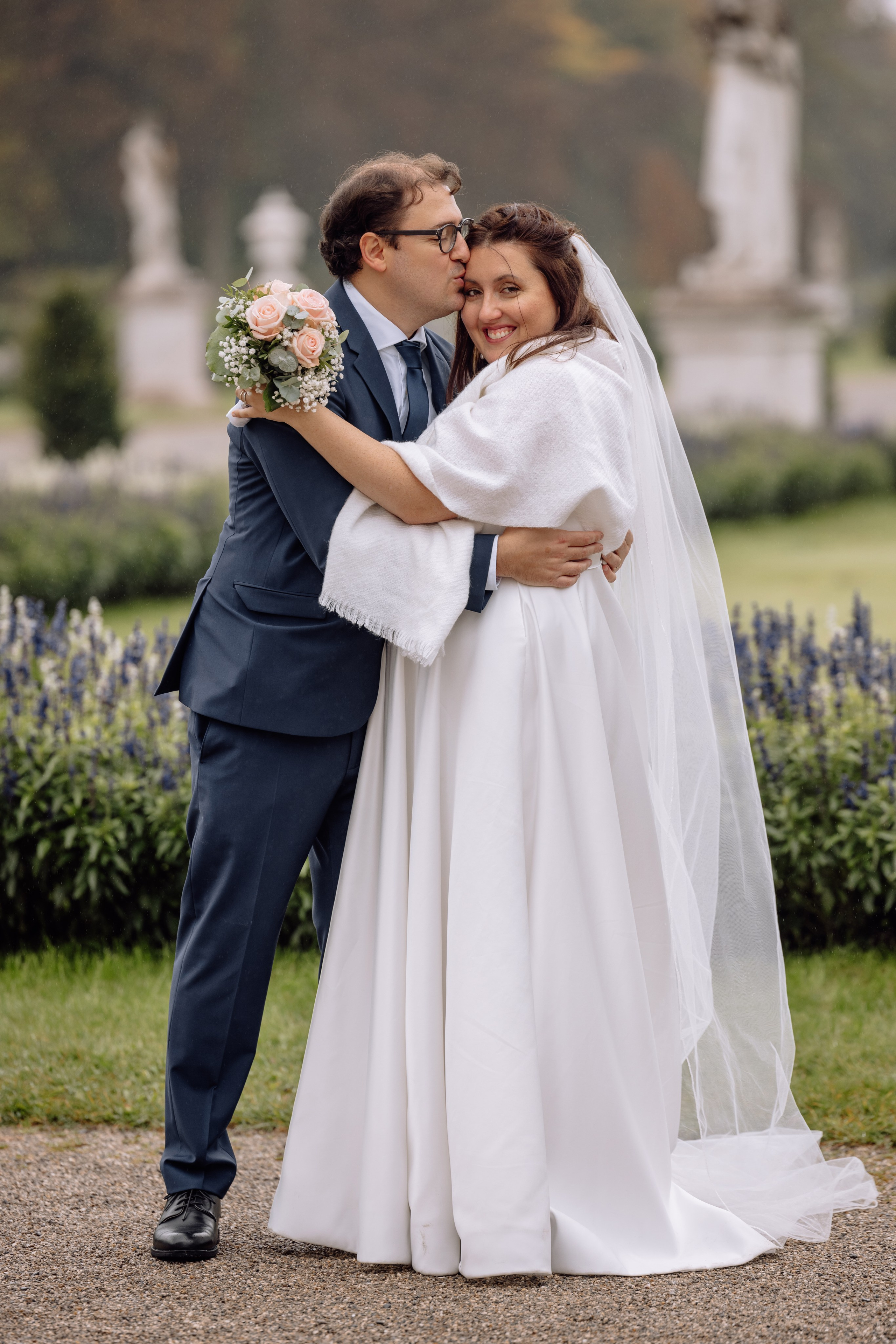 Bräutigam küsst die Braut  vor dem Schloss Nymphenburg