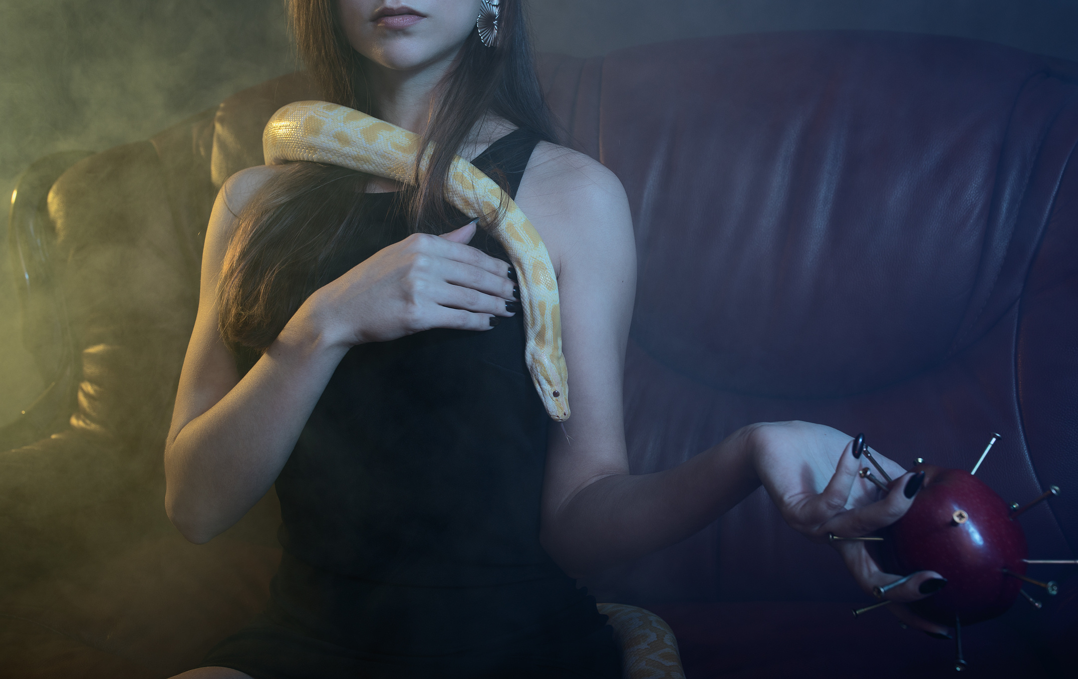 Conceptual close-up of woman with python and spiked apple — modern Eve theme