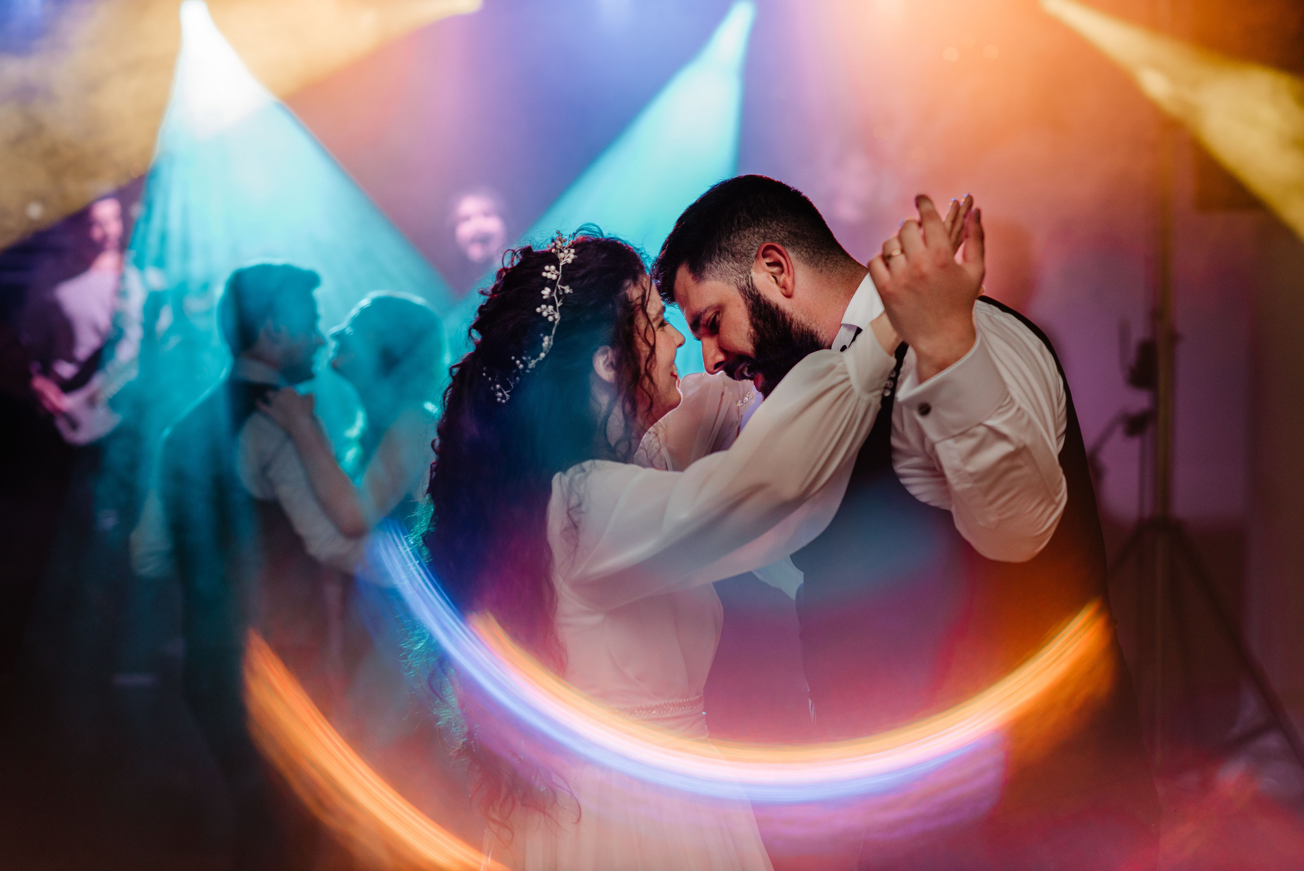 Radu Rahovan Fotograf de nuntă Cluj – mirii la dans în luminile proiectoarelor colorate cu reflexii ring of fire.