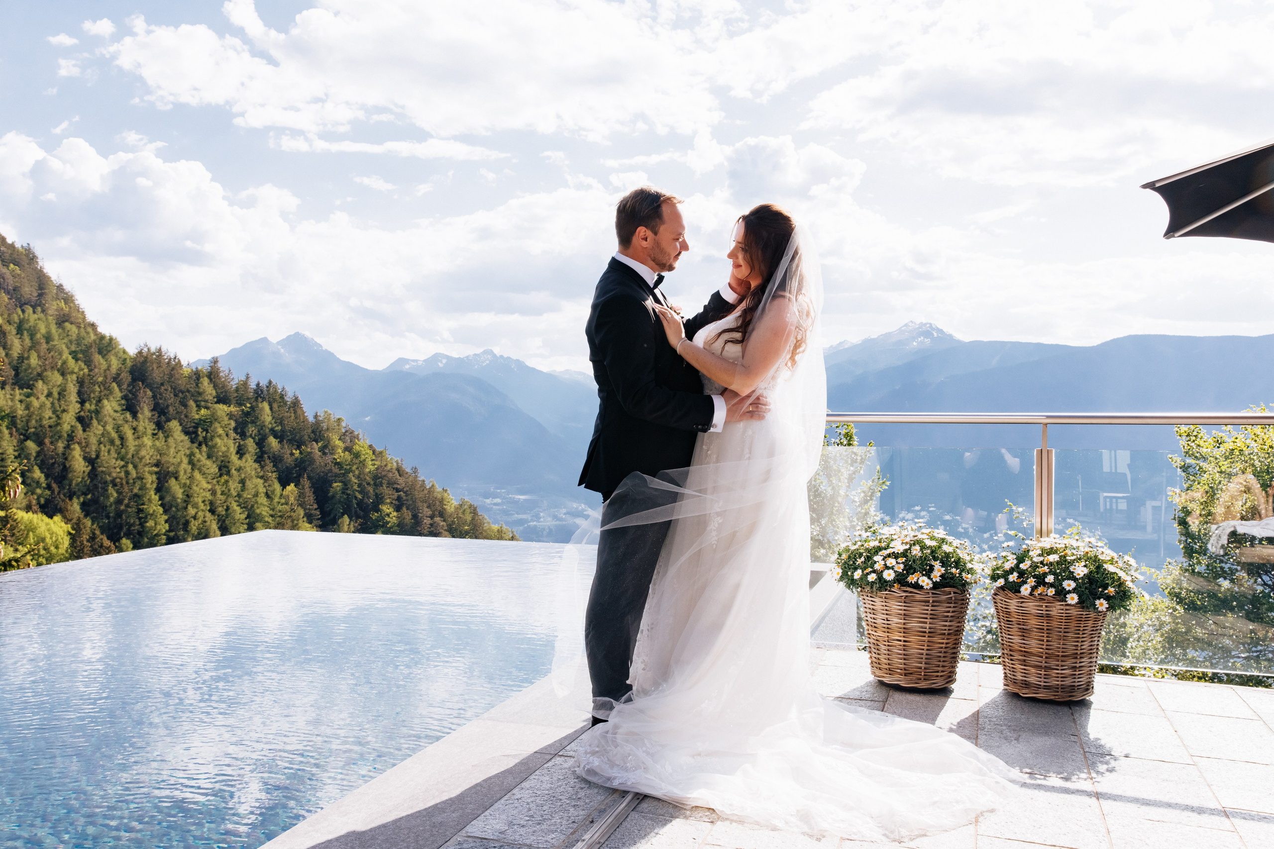 Bräutigam streichelt zärtlich das Gesicht der Braut am Pool des Miramonti Boutique Hotels in Südtirol – ein intimer Hochzeitsmoment in idyllischer Atmosphäre.