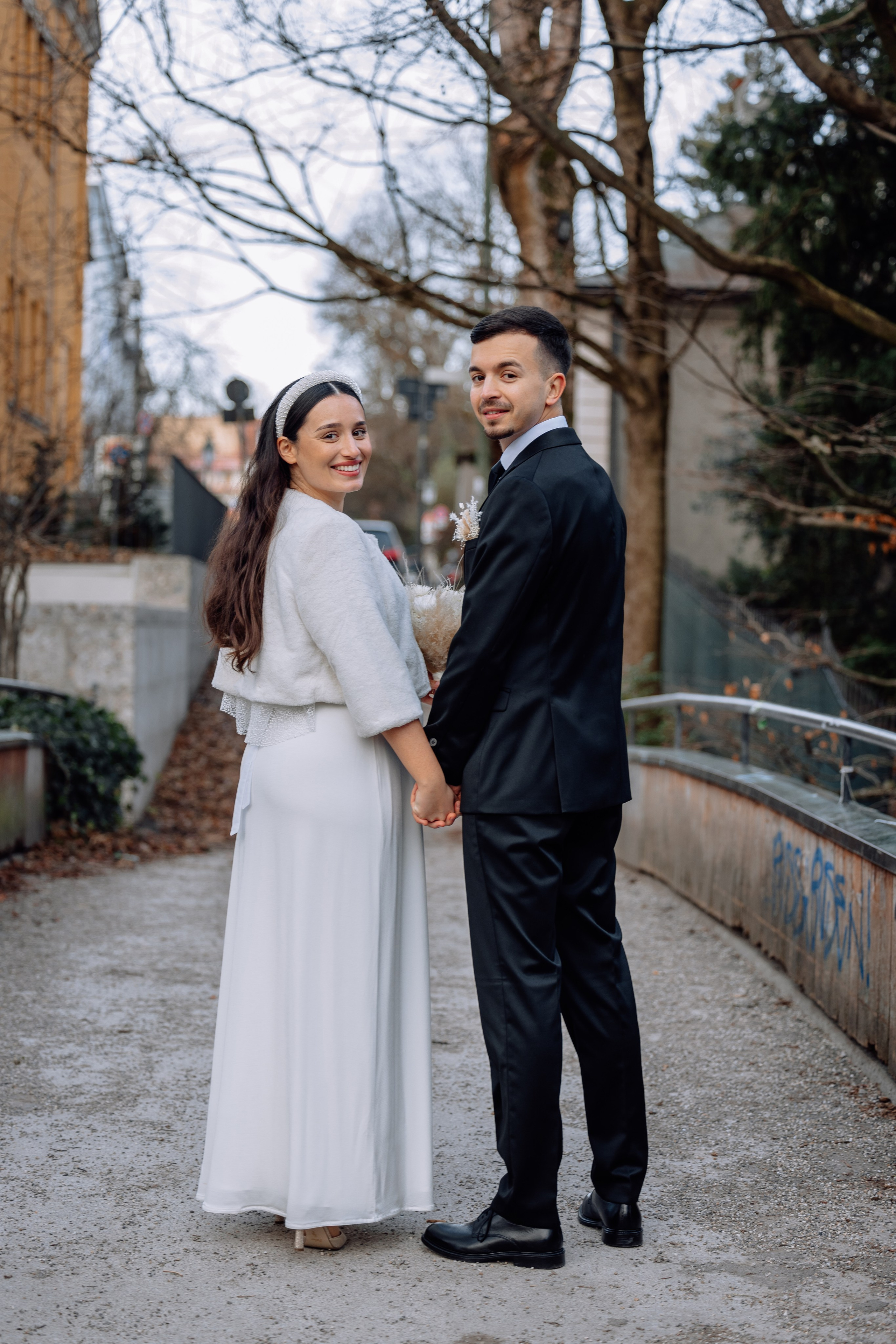 Braut und Bräutigam halten sich an den Händen – Spaziergang Standesamt Schwabing