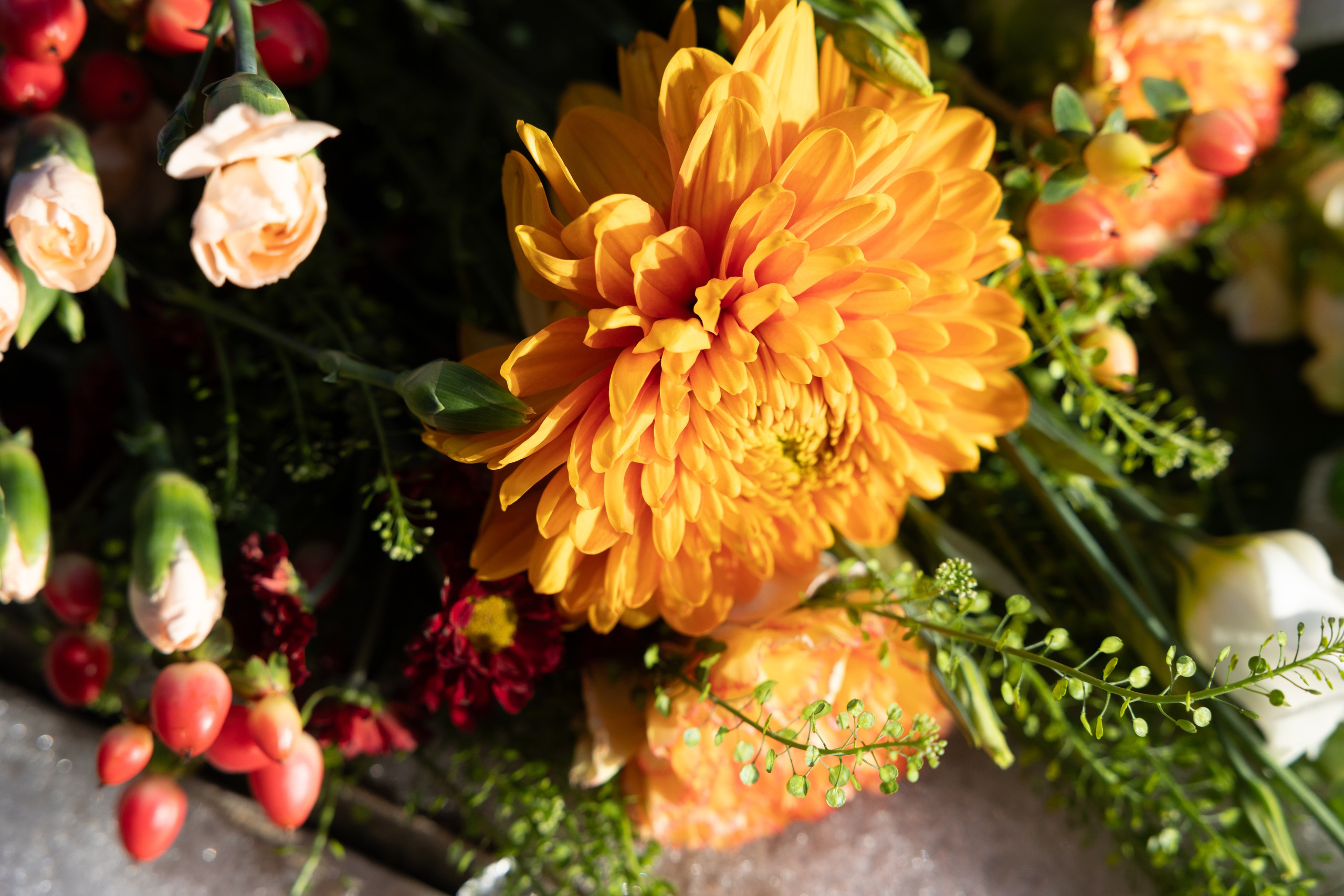 Bårebuket i varme farver Send et kærligt sidste farvel. De gyldne farver i denne bårebuket, skaber et fyldigt, varmt og hjerteligt udtryk.