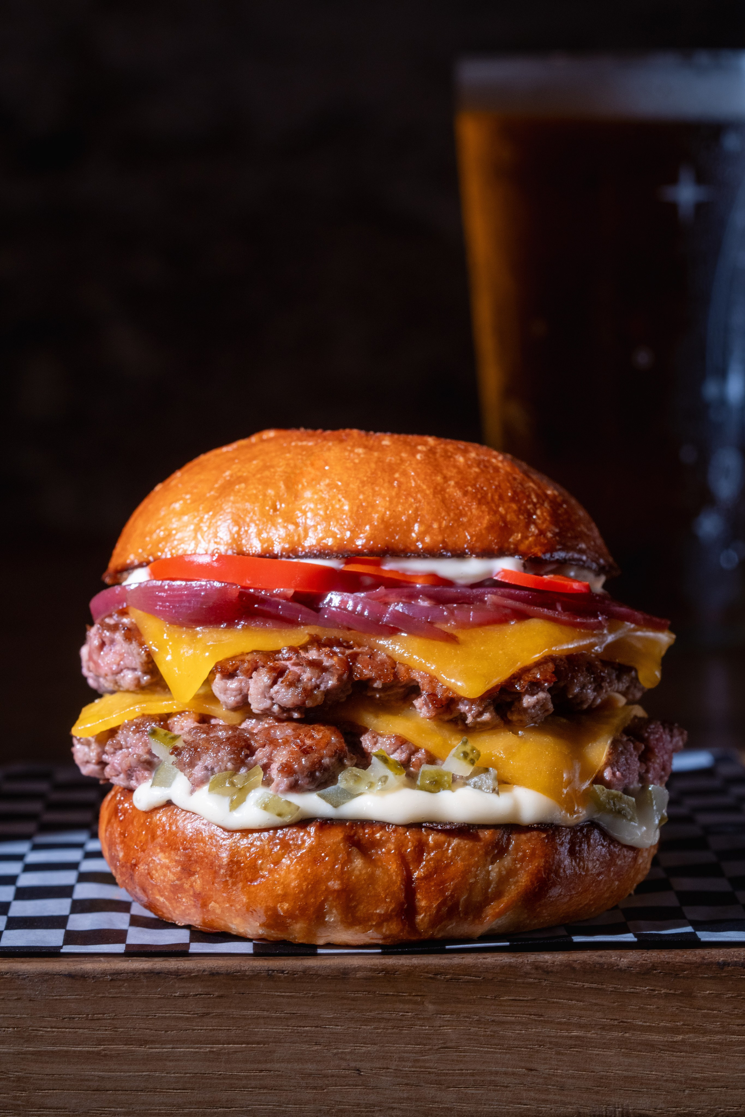 Grande plano de um suculento cheeseburger com Double Patty e Cheddar. Delicioso cheeseburger duplo com queijo cheddar, picles, cebola e tomate em pão torrado.