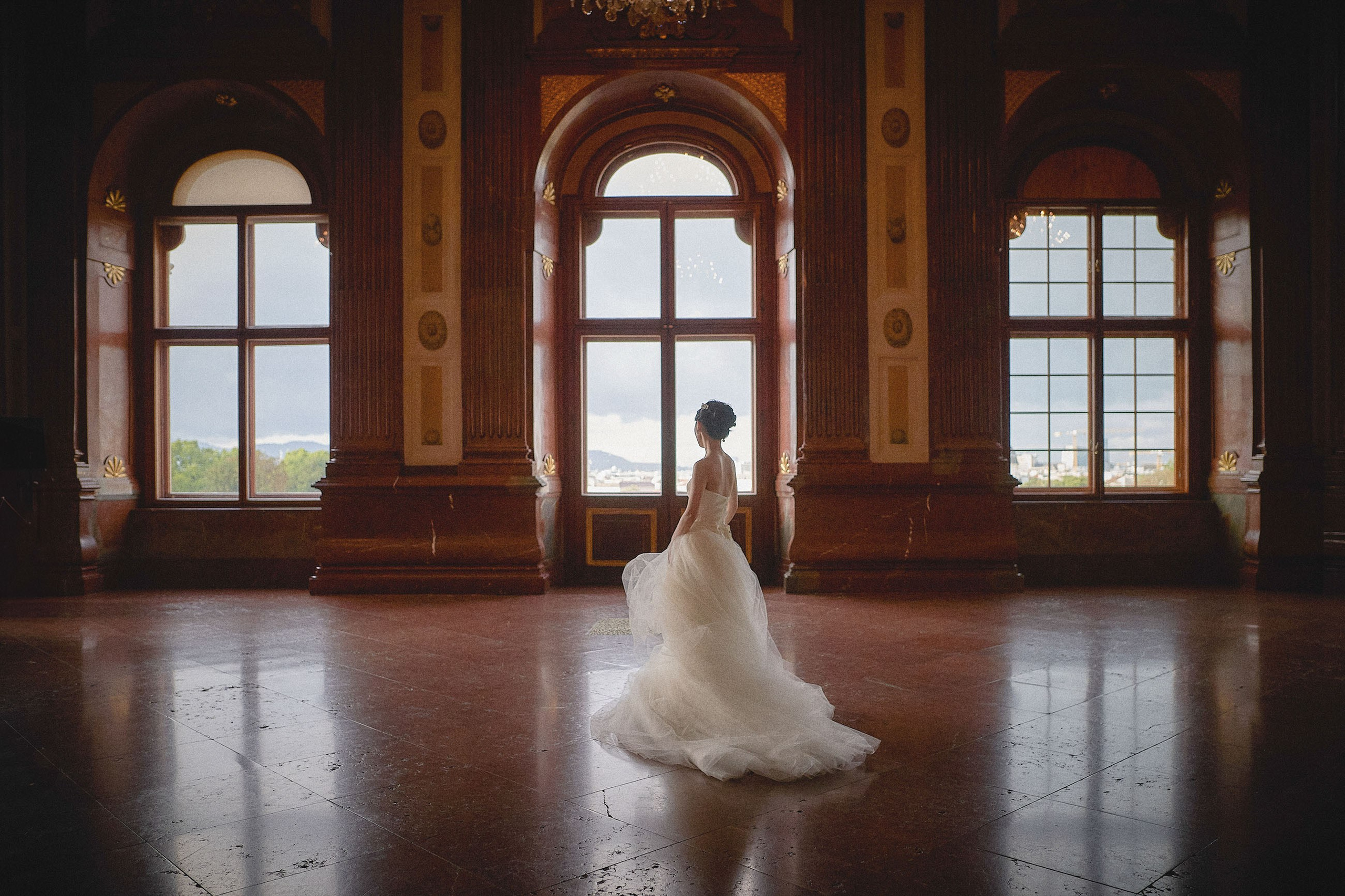 The historic hall of the baroque Belvedere Palace provides the opulent backdrop as the bride twirls her veil.