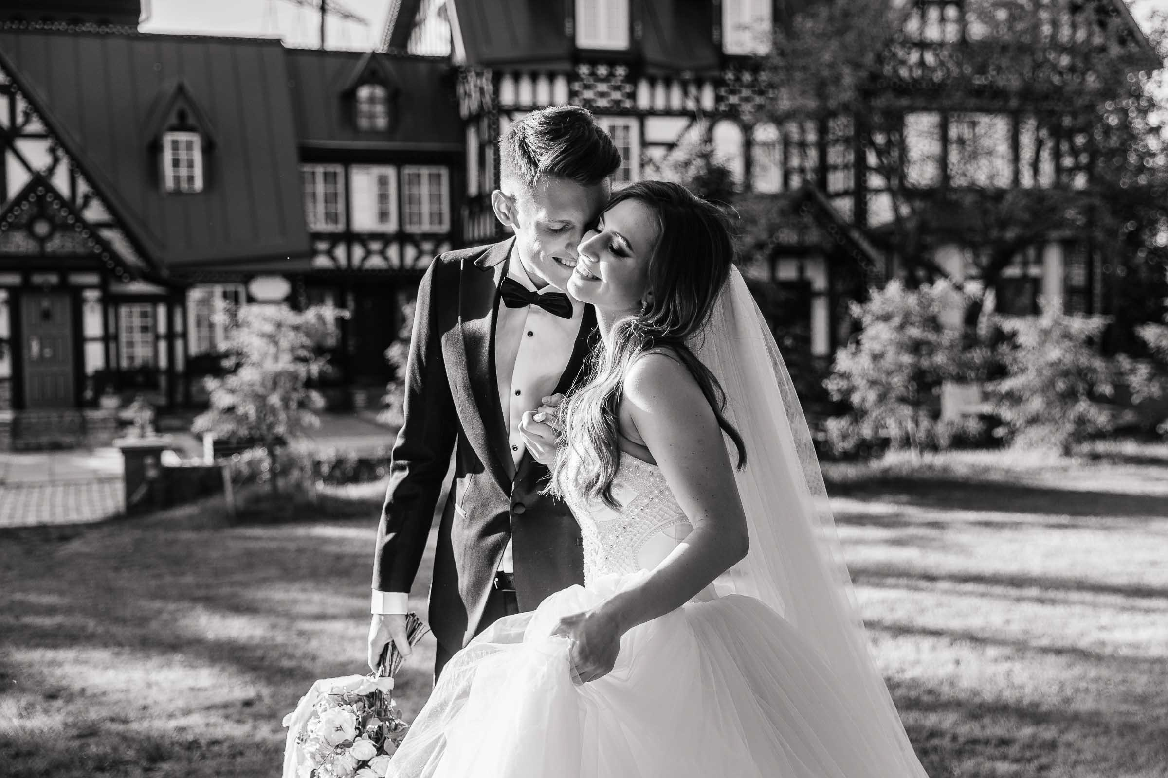 Bride and groom walking in gardens by grand house, by Tanya Bodgan, Bude, Cornwall wedding photographer.