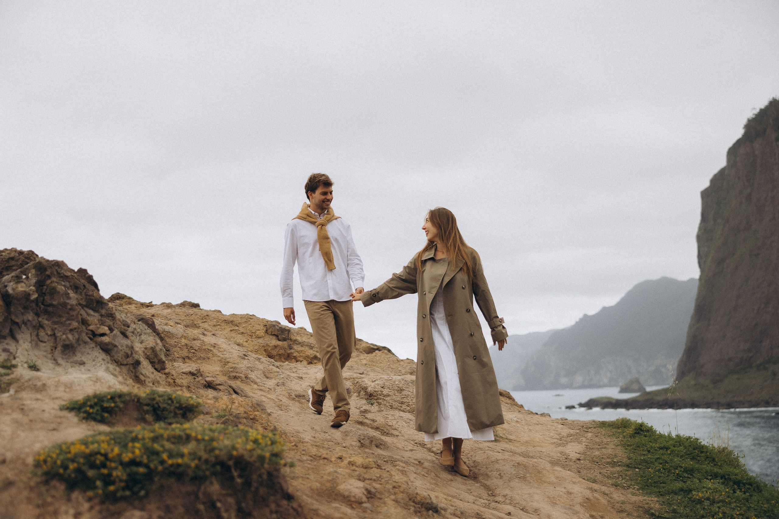 Romantic surprise proposal at sunset on a scenic cliffside in Madeira, Portugal, capturing the emotional moment of love and commitment.