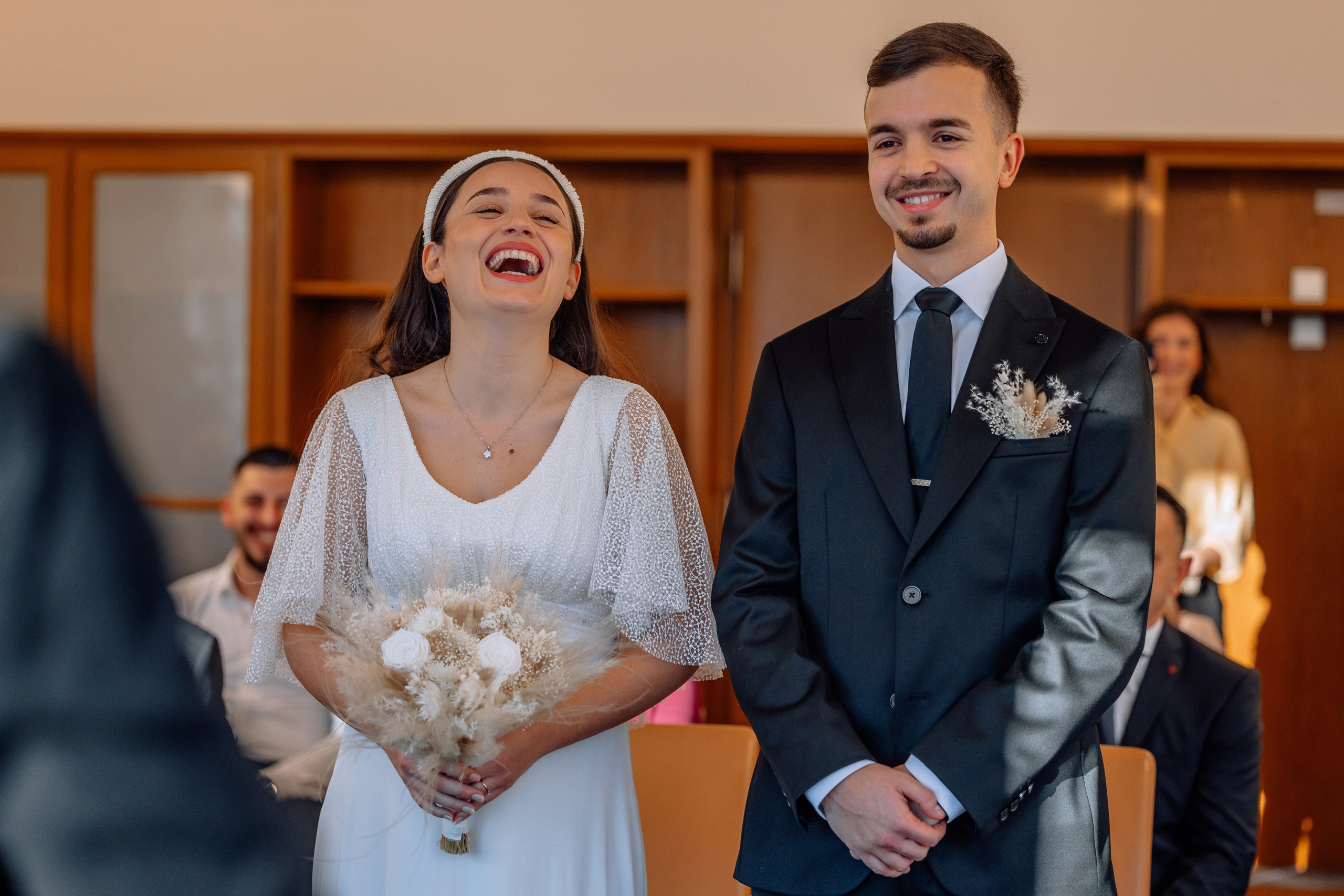 Schwangere Braut lacht mit Bräutigam im Standesamt Schwabing