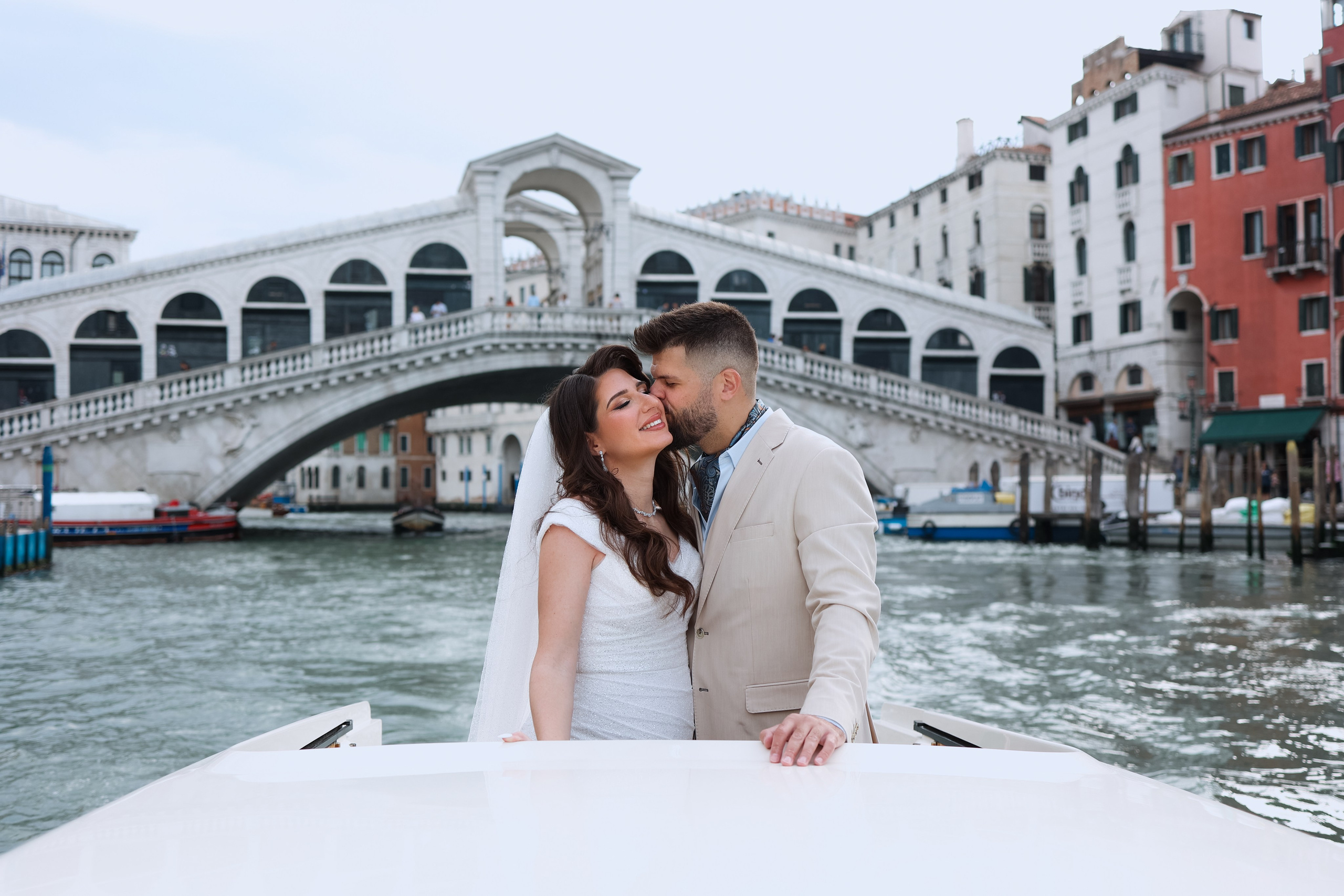 Couple on water taxy next to Rialto bridge 
