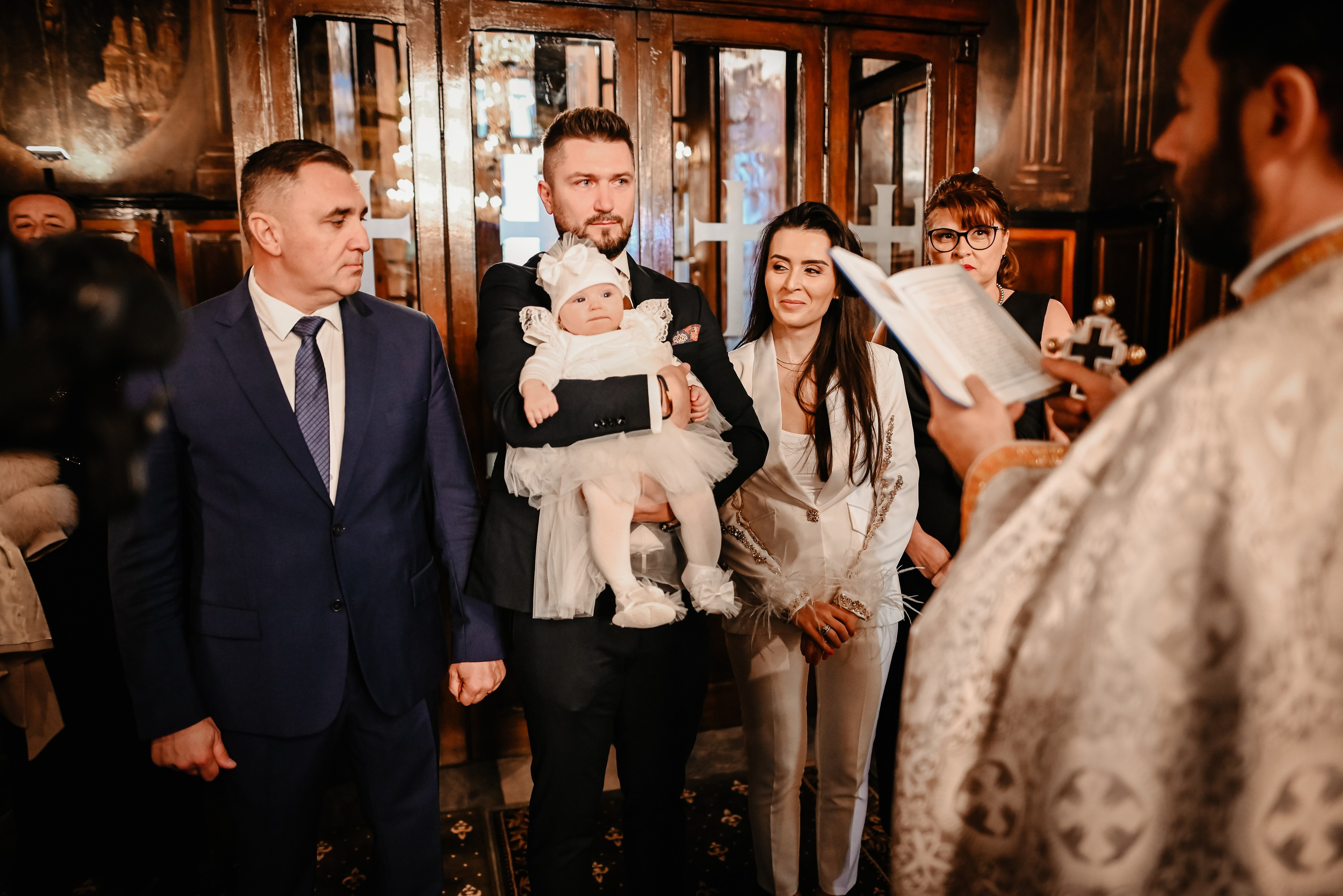 Nașii țin copilul în brațe – fotografie simbolică de botez Ana Maria Drăgan