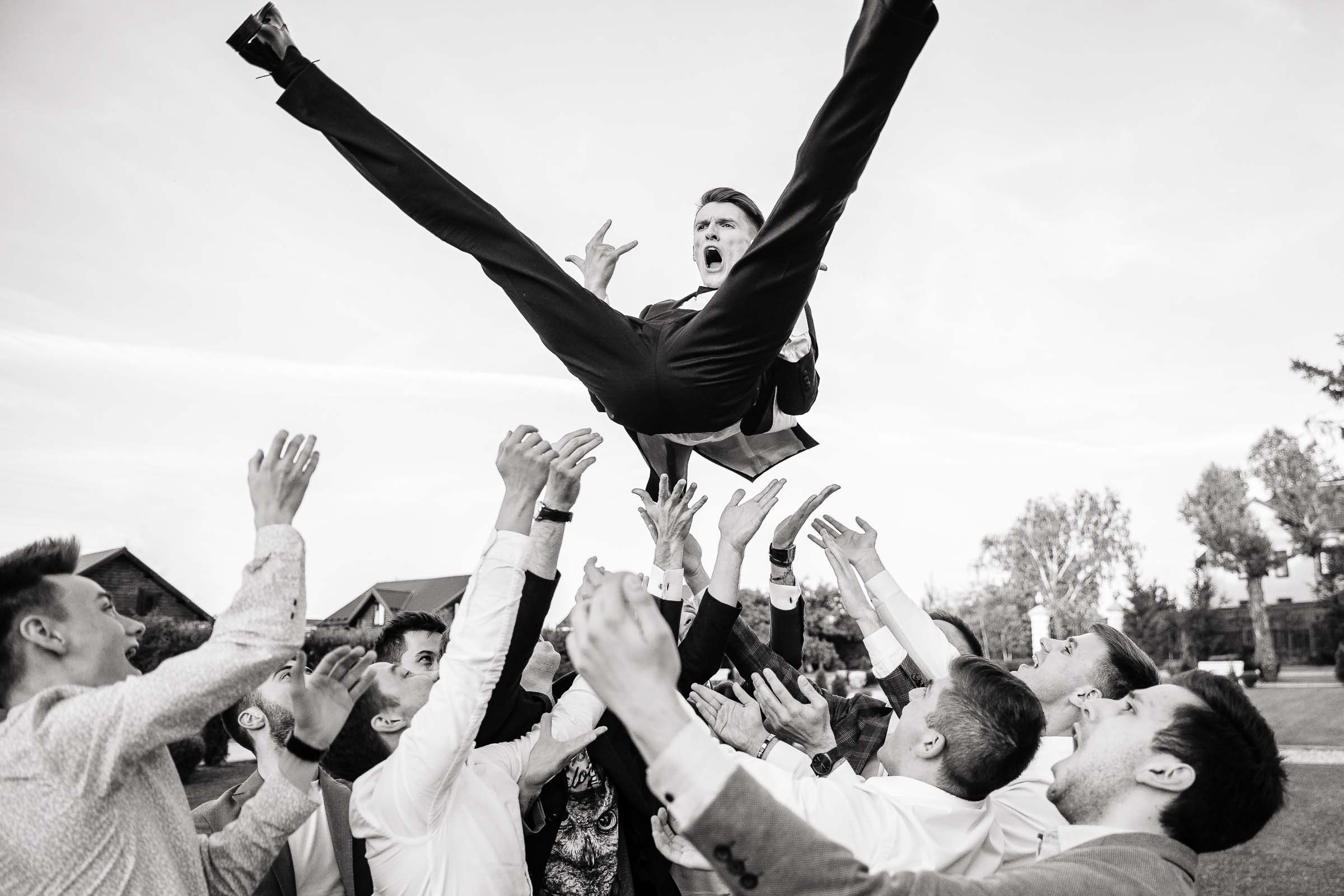 Groomsmen throwing groom, by Tanya Bodgan, Bude wedding photography.