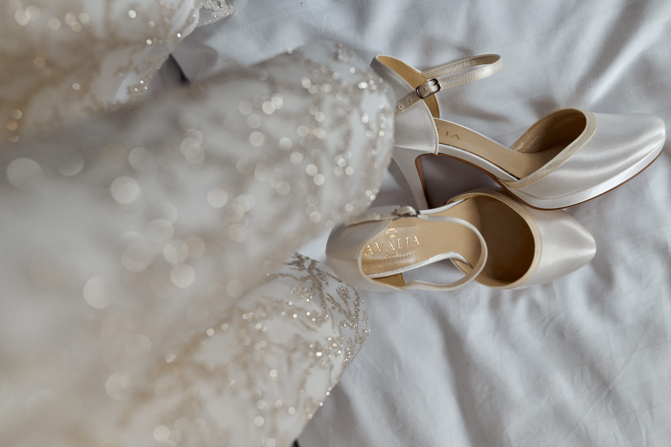 Detailaufnahme der schimmernden Brautschuhe und des verzierten Hochzeitskleids – festgehalten vor der Trauung von Alis im Schloss Meßkirch.