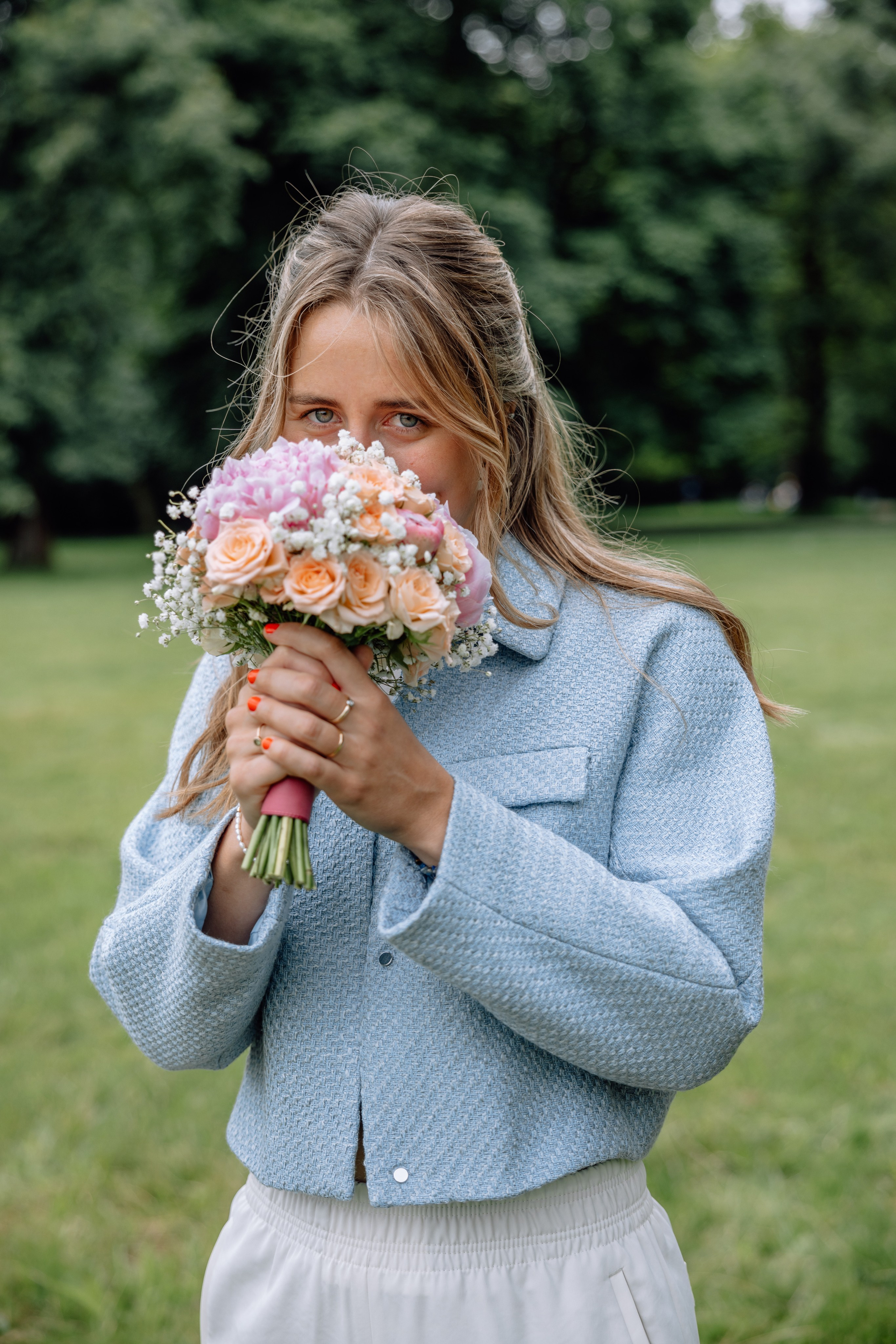 Braut riecht an ihrem Blumenstrauß – romantischer Moment vor Standesamt Schwabing