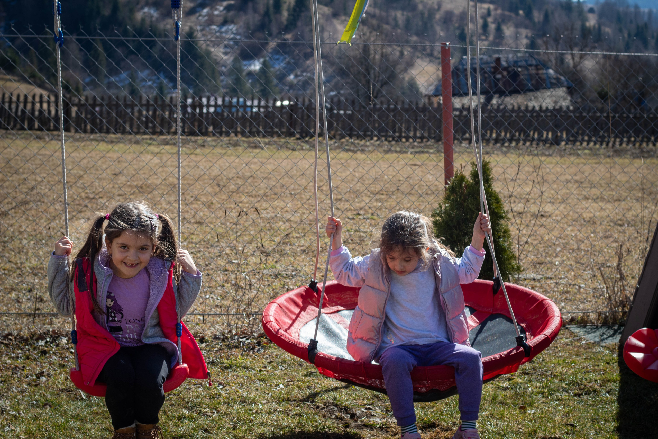 Group of children running across a green field during an outdoor play session.