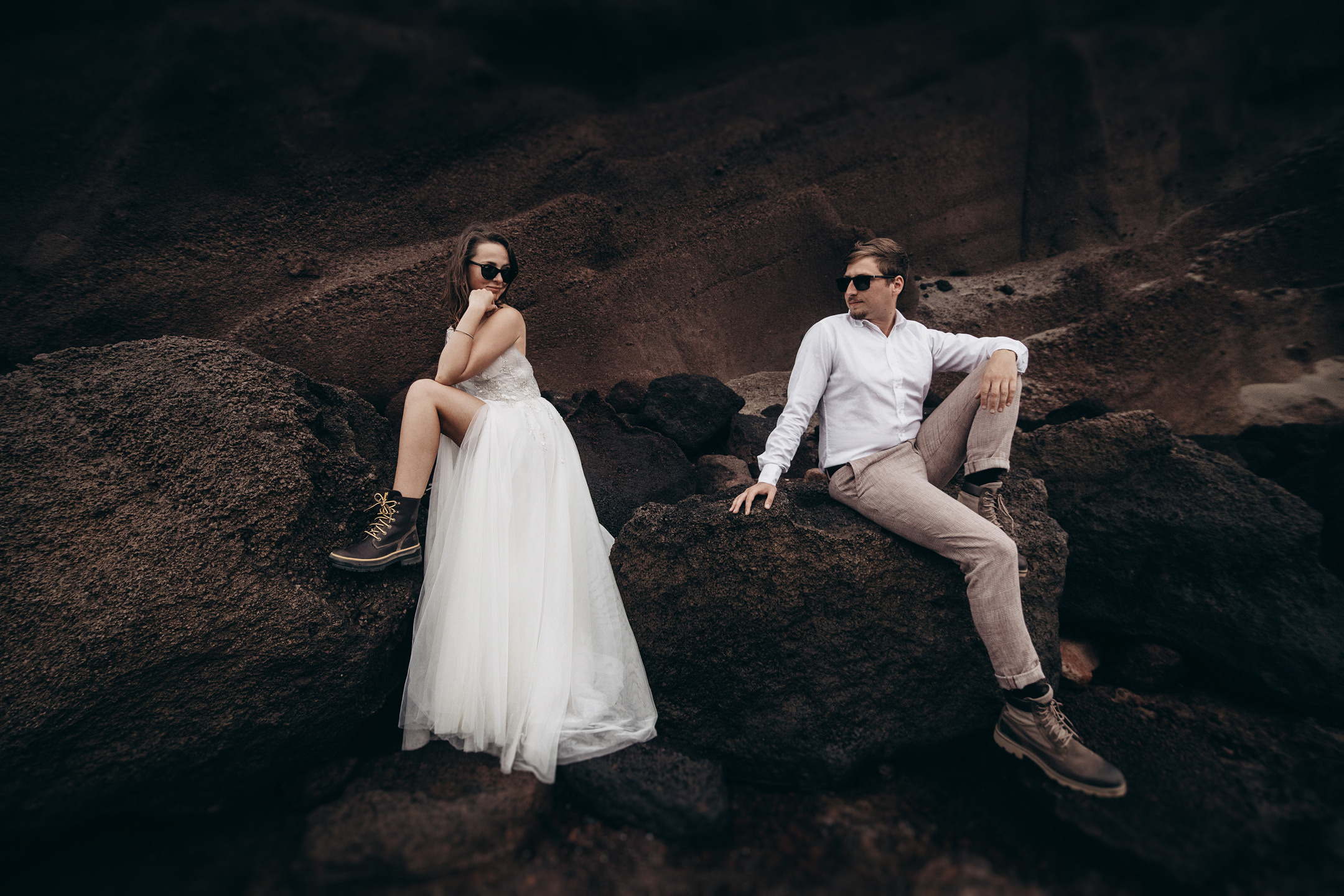 Dramatic wedding couple sitting in the rock