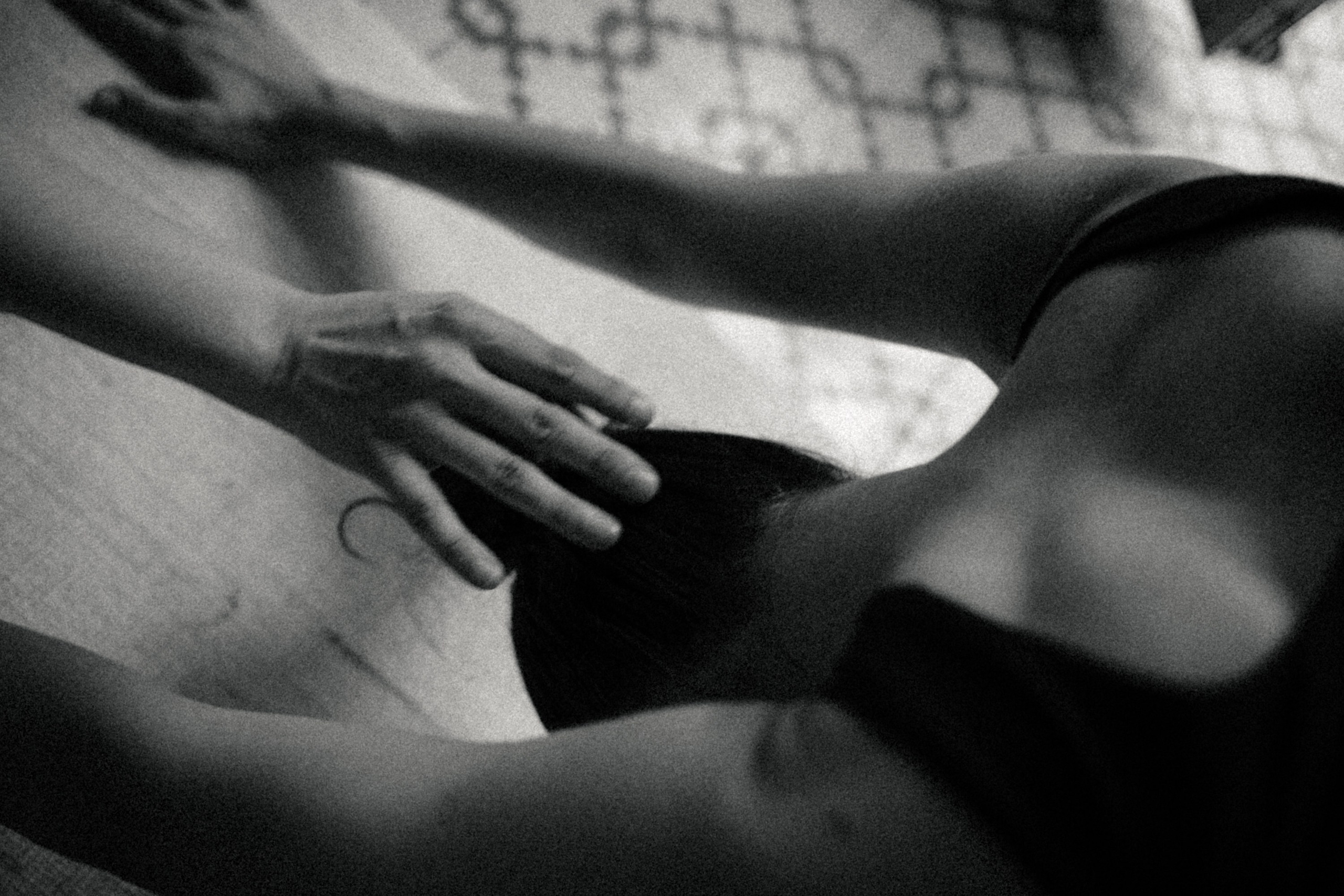 Black and white image of a hand resting gently on someone’s chest