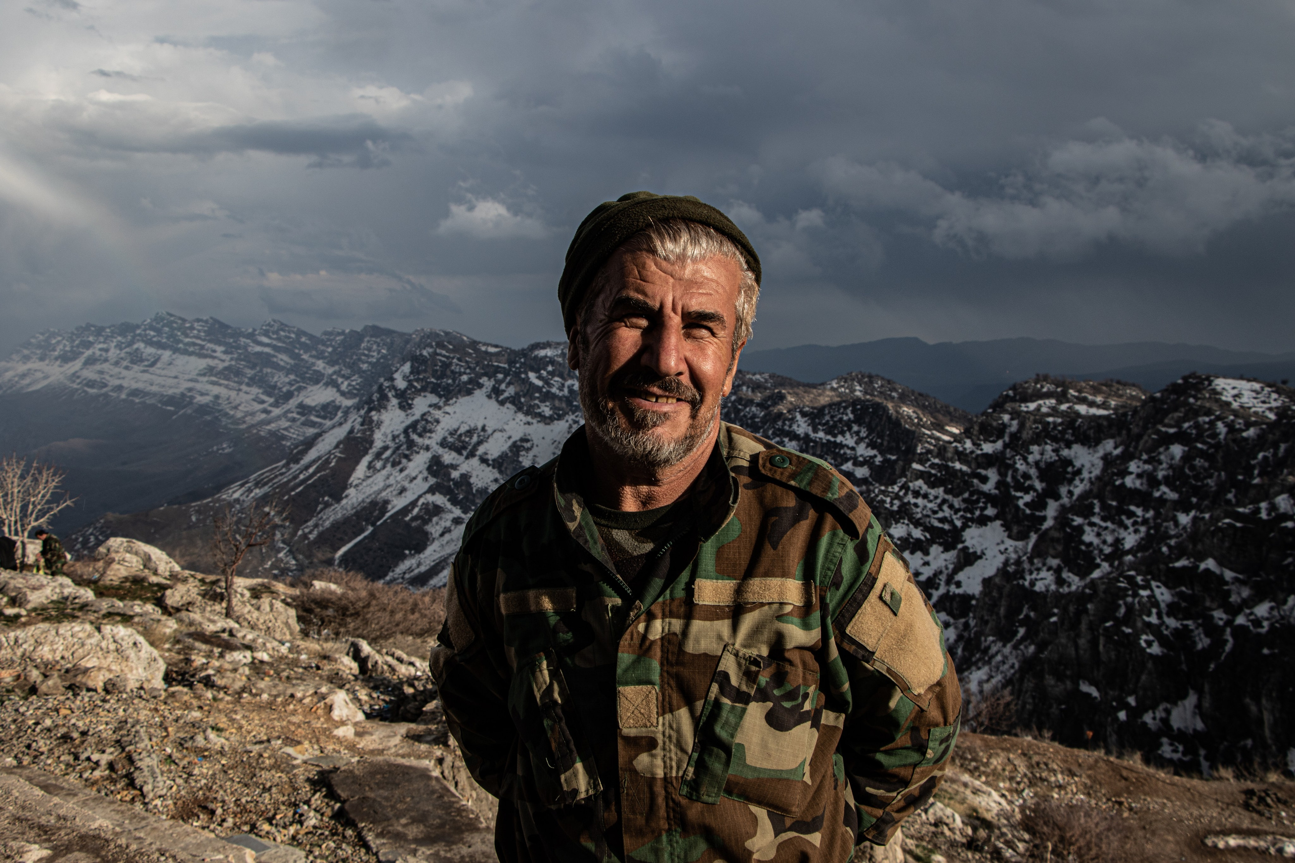 Un peshmerga surveille les montagnes kurdes, scrutant les environs depuis un poste avancé.