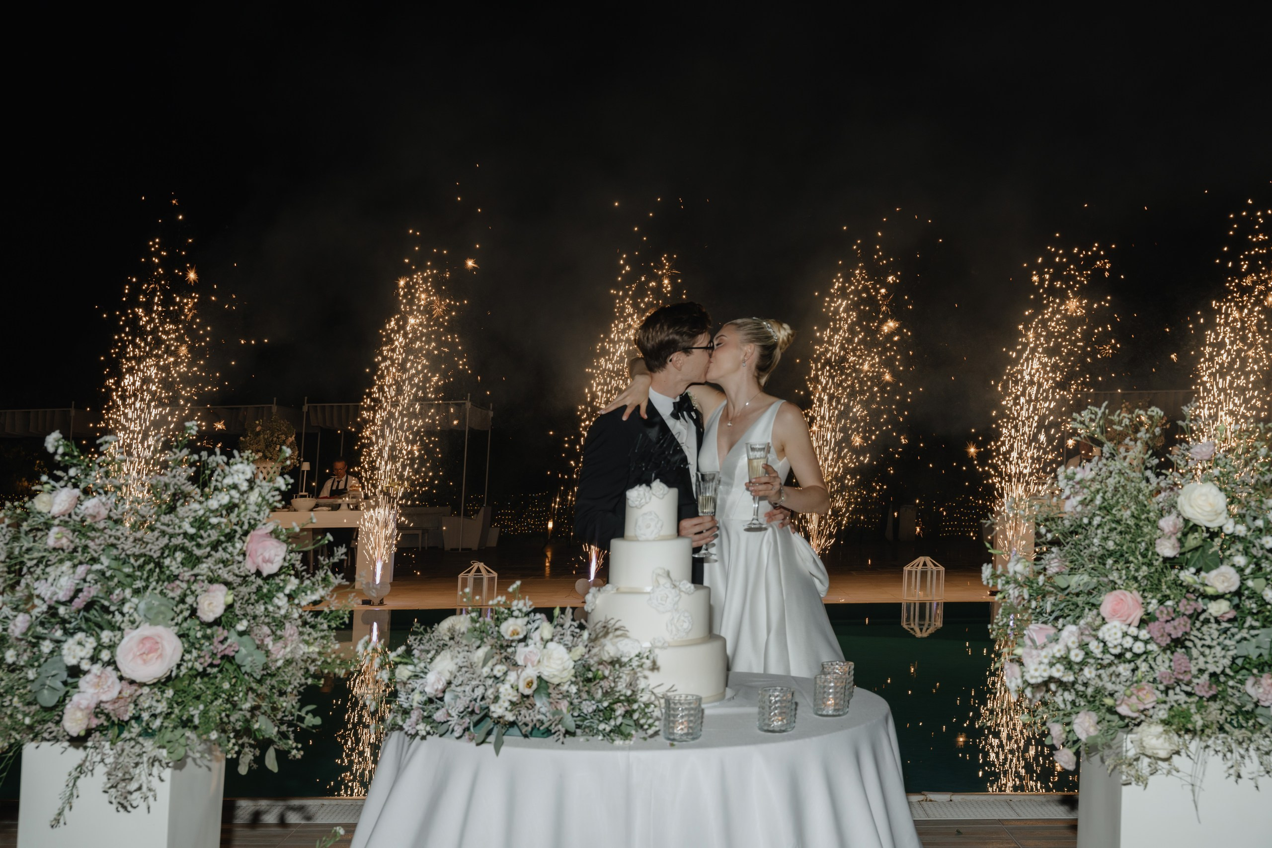Bride and groom cutting wedding cake during reception at Masseria Traetta Ostuni
