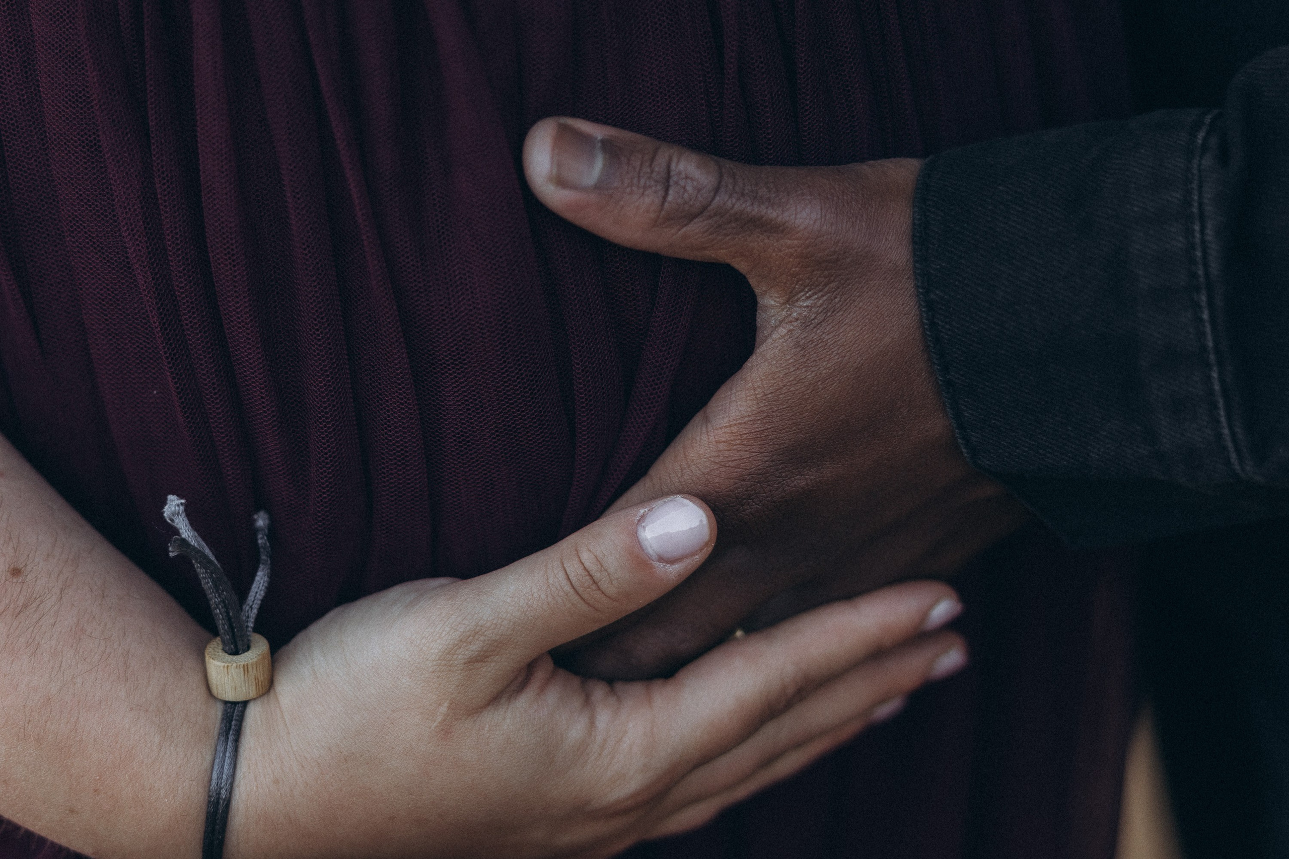 A glowing expectant mother standing on a cliff overlooking the ocean in Madeira, her dress flowing gently in the wind as the golden sunset casts a warm glow.
