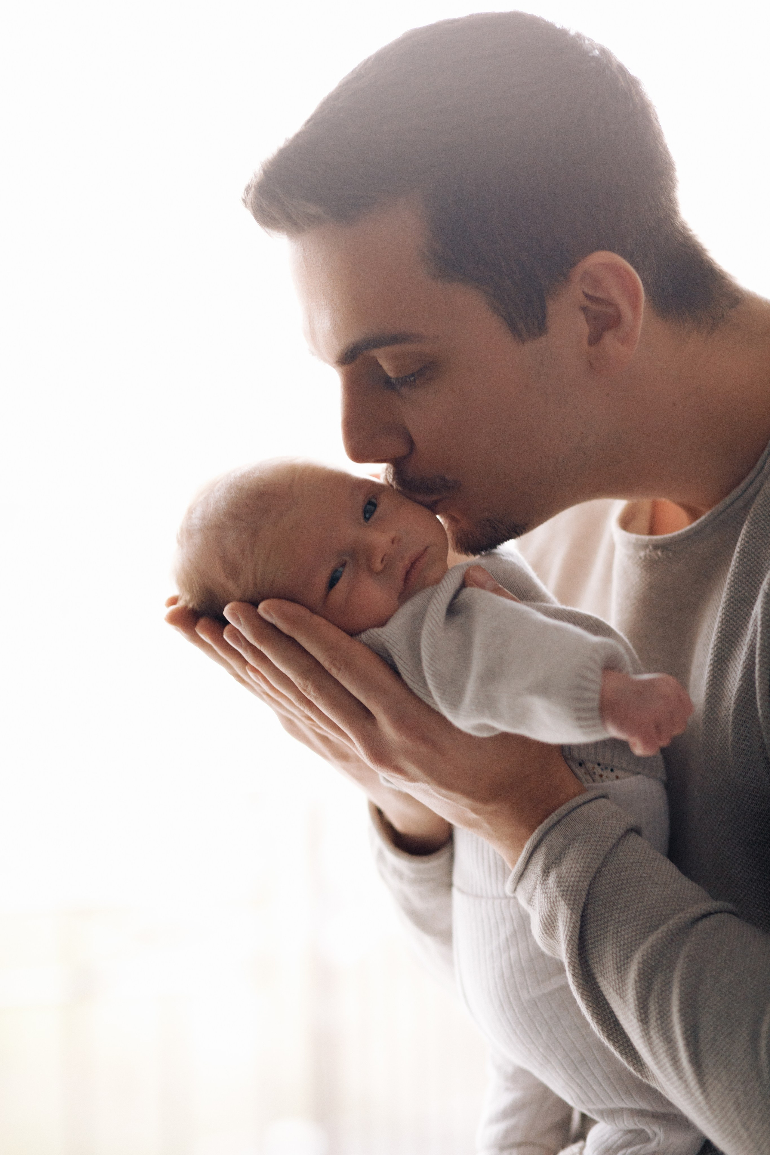 Vater küsst seinen Sohn liebevoll auf die Wange.