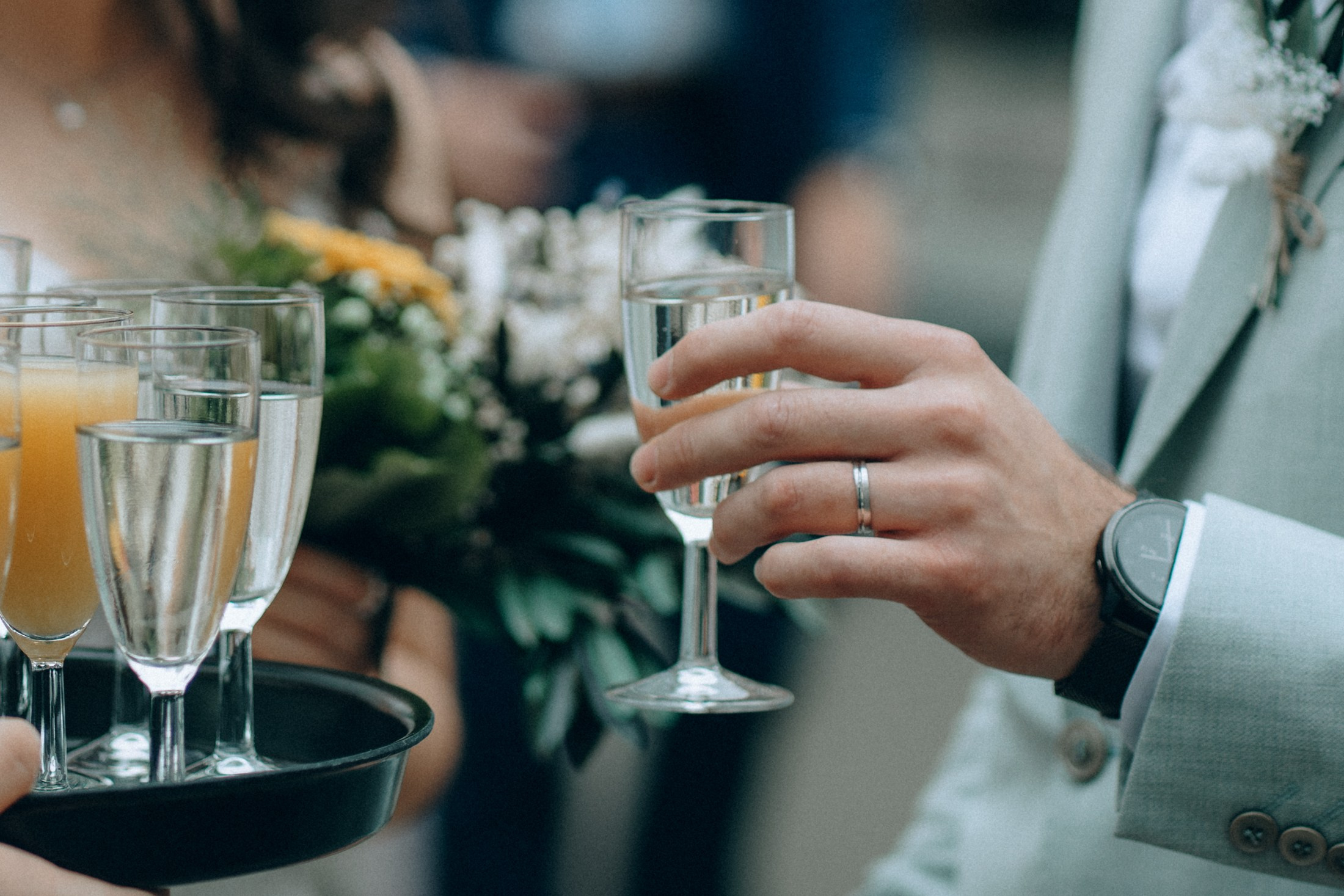 Свадебный банкет — жених и невеста чокаются бокалами шампанского