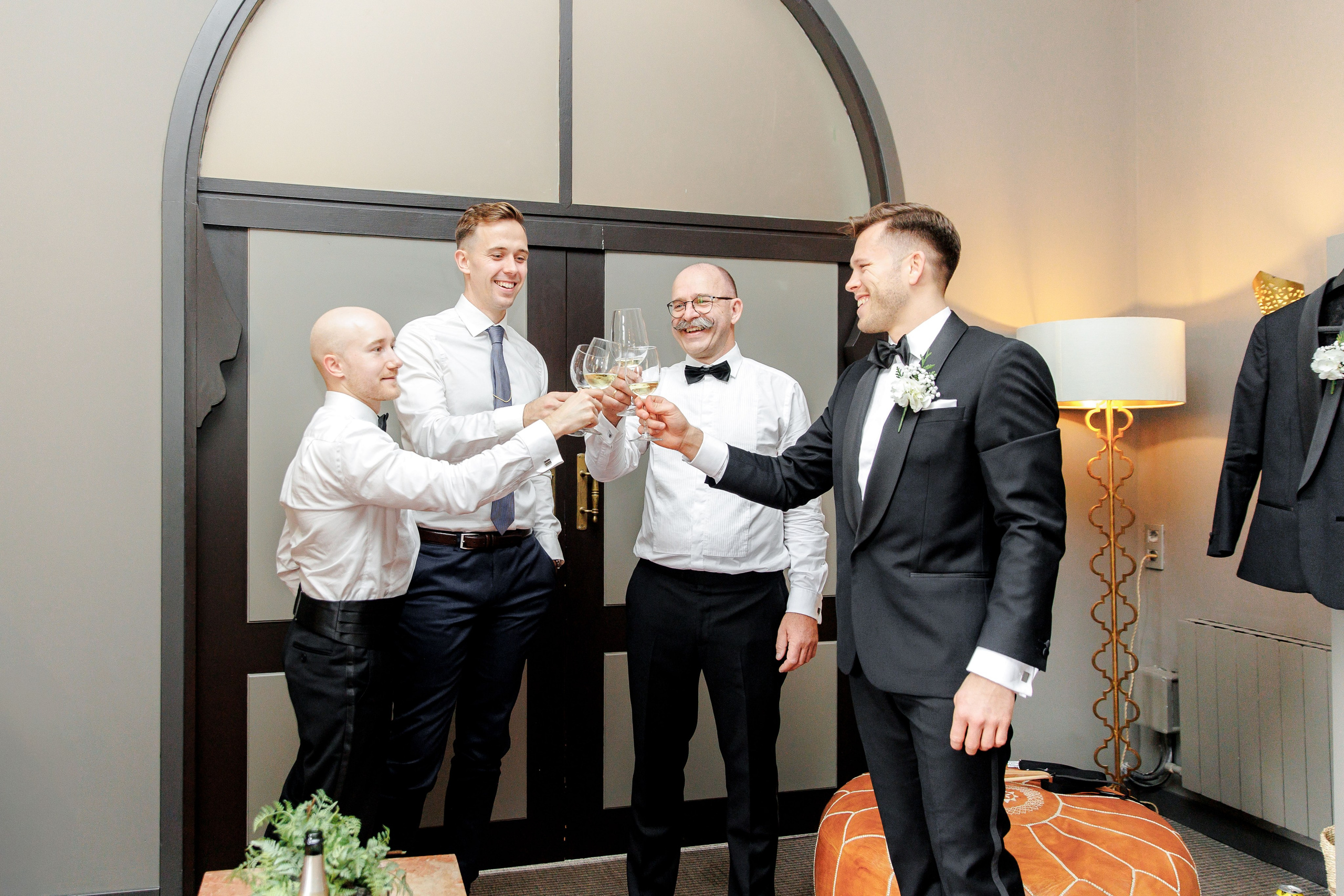 Candid shot of the groom laughing with friends during preparations for his wedding day in Barcelona.