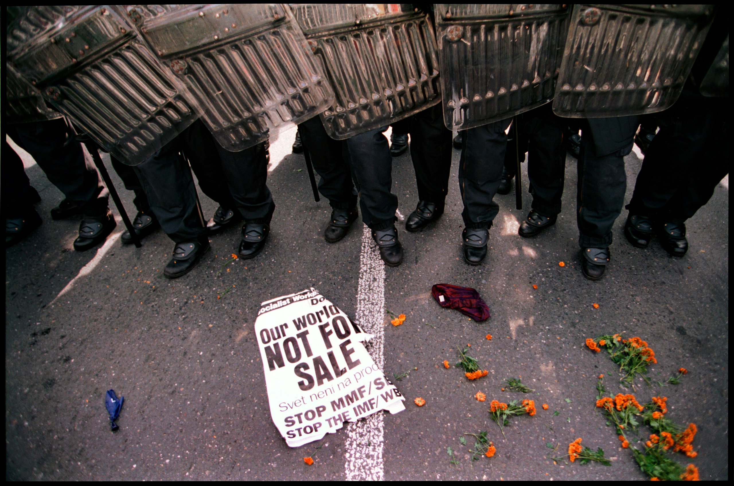 An anti IMF/World Bank sign lays at the fee of riot police as they face off with violent protestors on Nusle Bridge leading to the Congress Center in Prague on September 27, 2000. The annual meeting of the World Bank and IMF ended early amid confusion after anti-globalisation protesters brought Prague to a standstill.