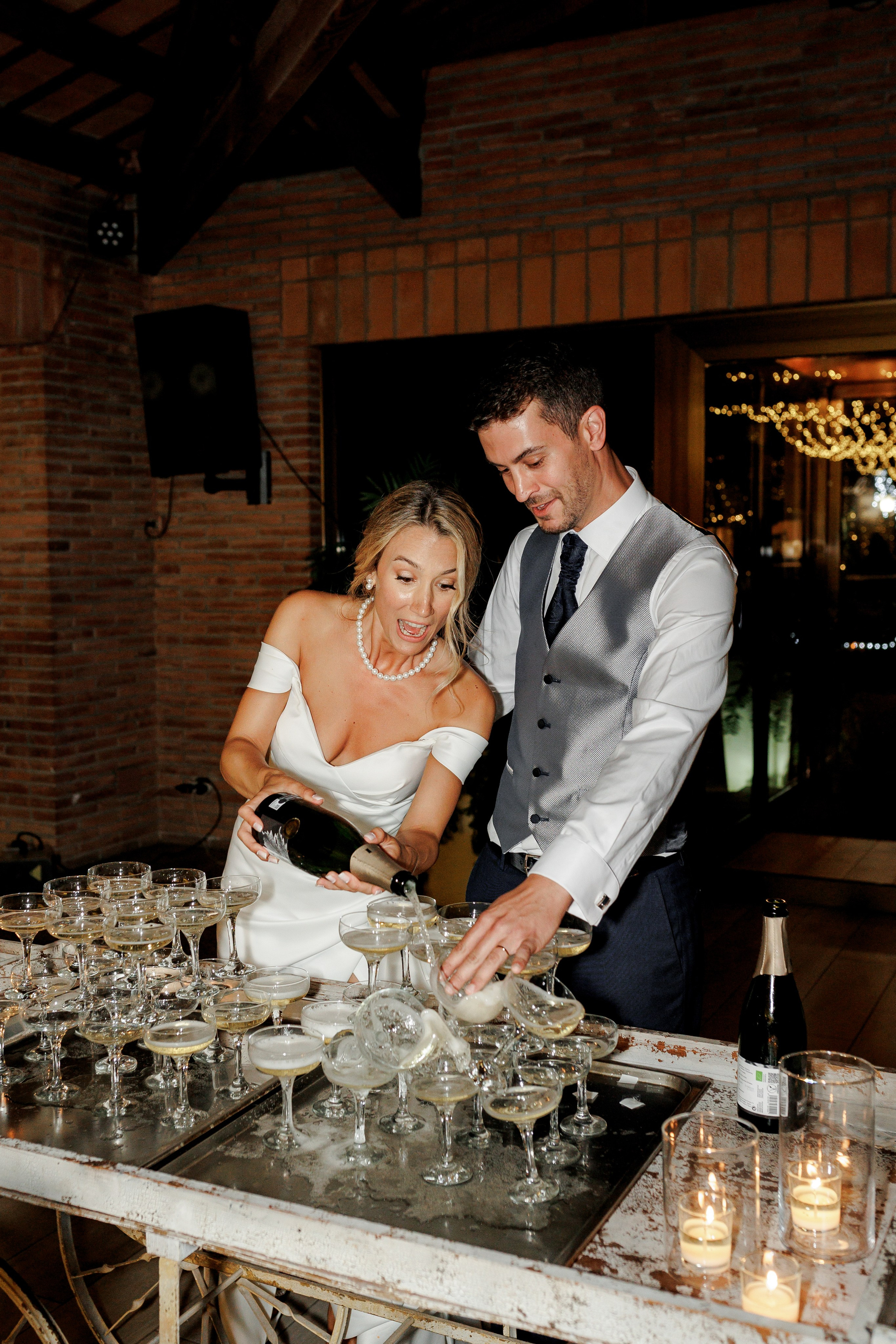 Newlyweds celebrating the dinner with oppening champagne tower 