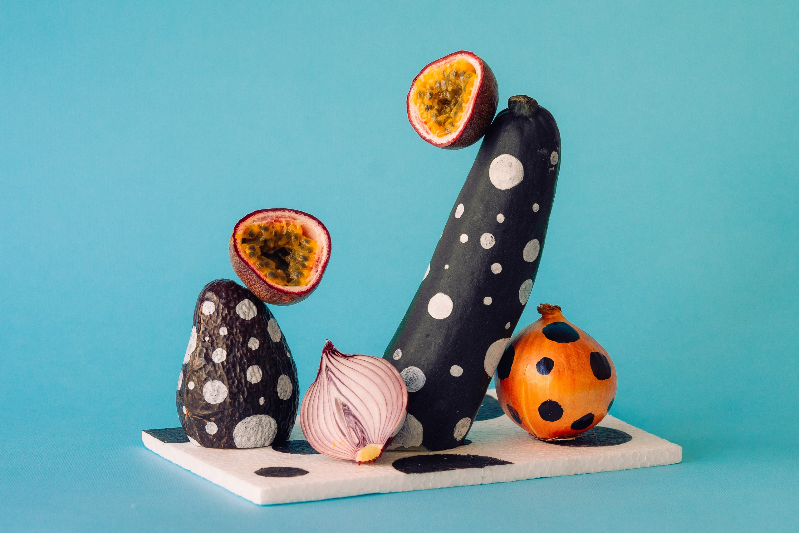Spotted Pattern Painted Vegetable Art Composition. Arranjo artístico de vegetais pintados em um fundo azul vívido.