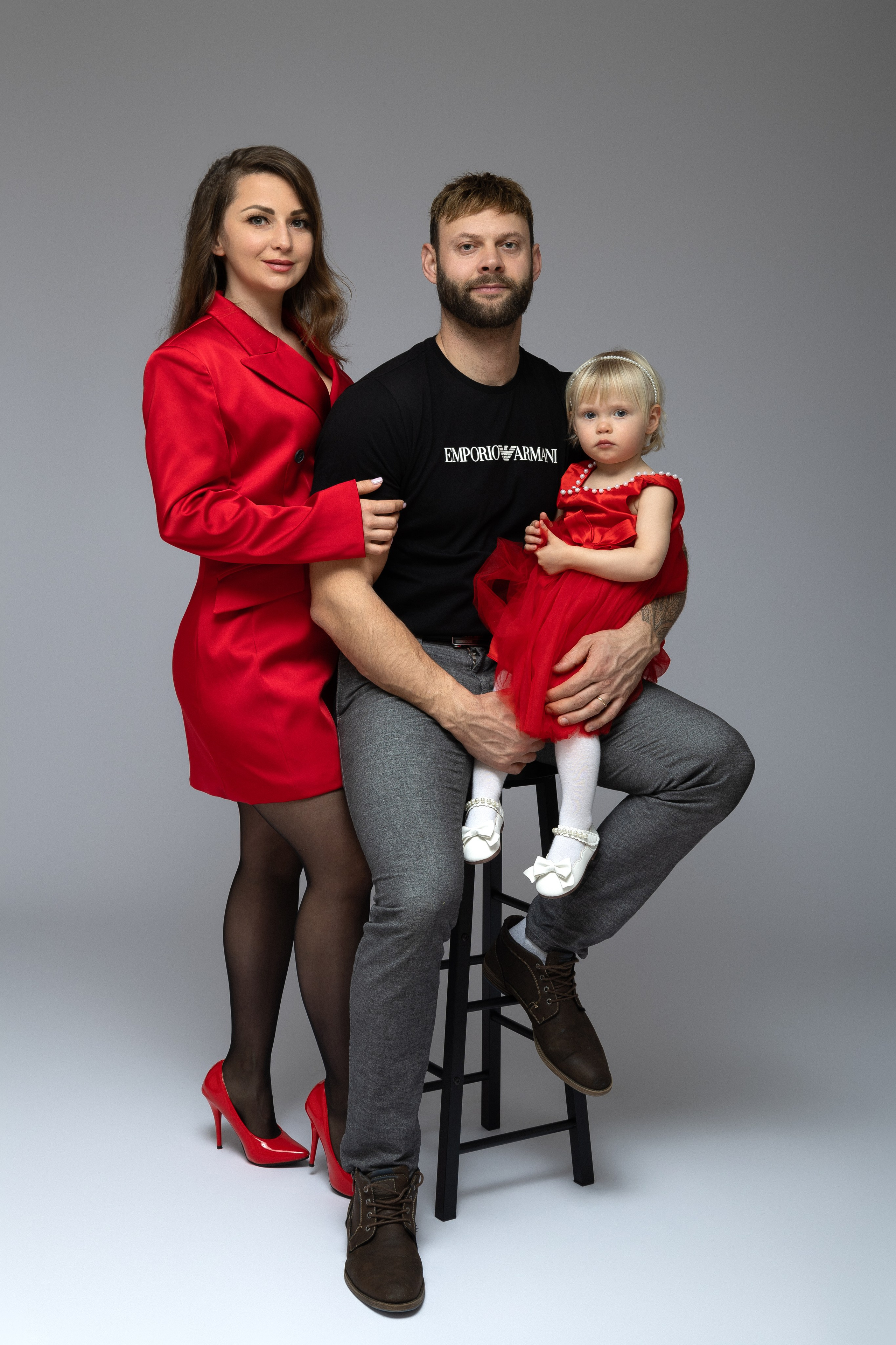 Familie schaut gemeinsam glücklich in die Kamera – strahlende Gesichter