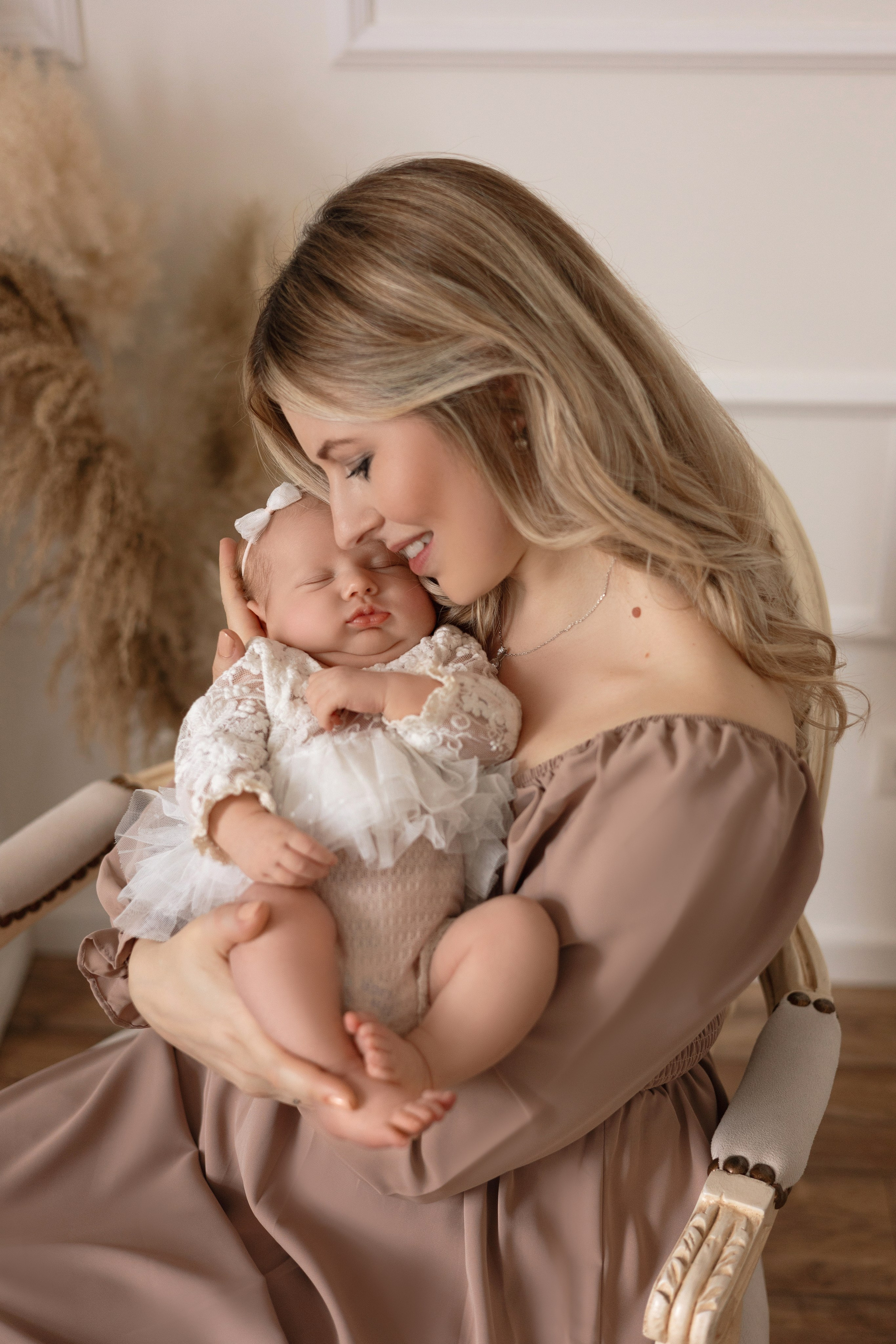 Emotionale Aufnahme einer Mutter, die ihr Neugeborenes liebevoll küsst – Babyfotoshooting in Iserlohn.