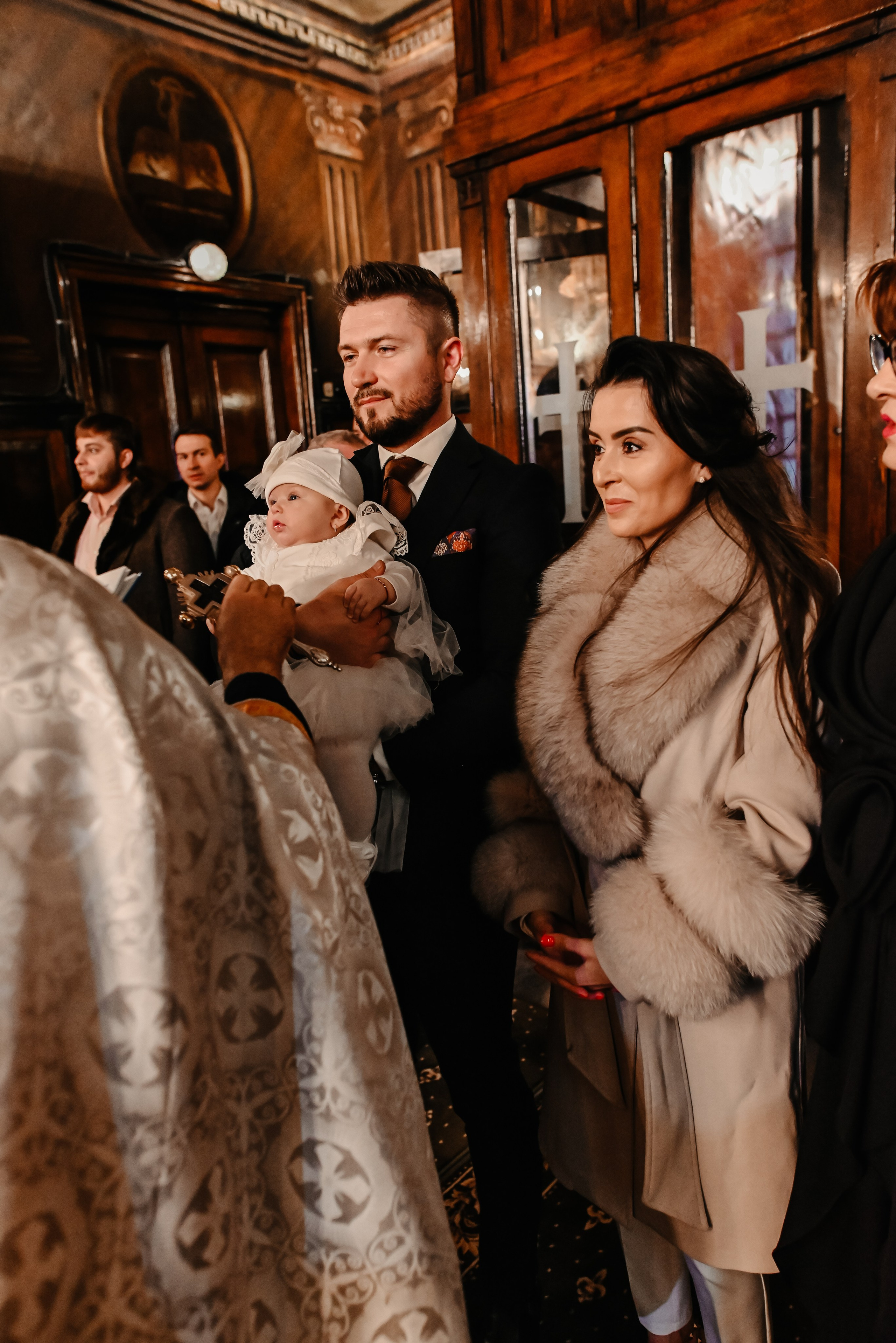 Nașii țin copilul în brațe ceremonial Biserica – fotografie simbolică de botez Ana Maria Drăgan