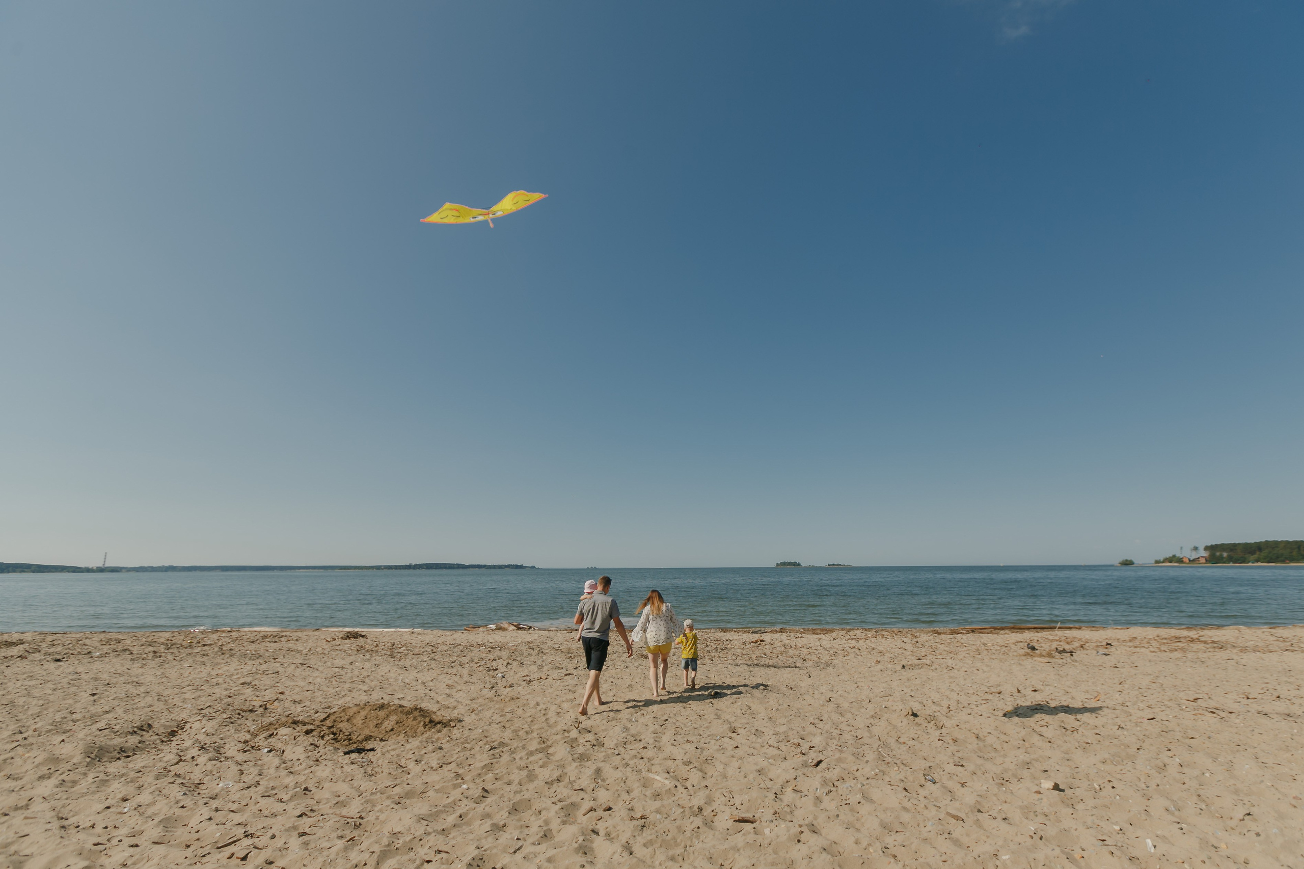 Familia volando una cometa en el lago y comiendo donas. Fotógrafo de retrato, familia y reportajes en Valencia | España | Europa Vitalii Lumier