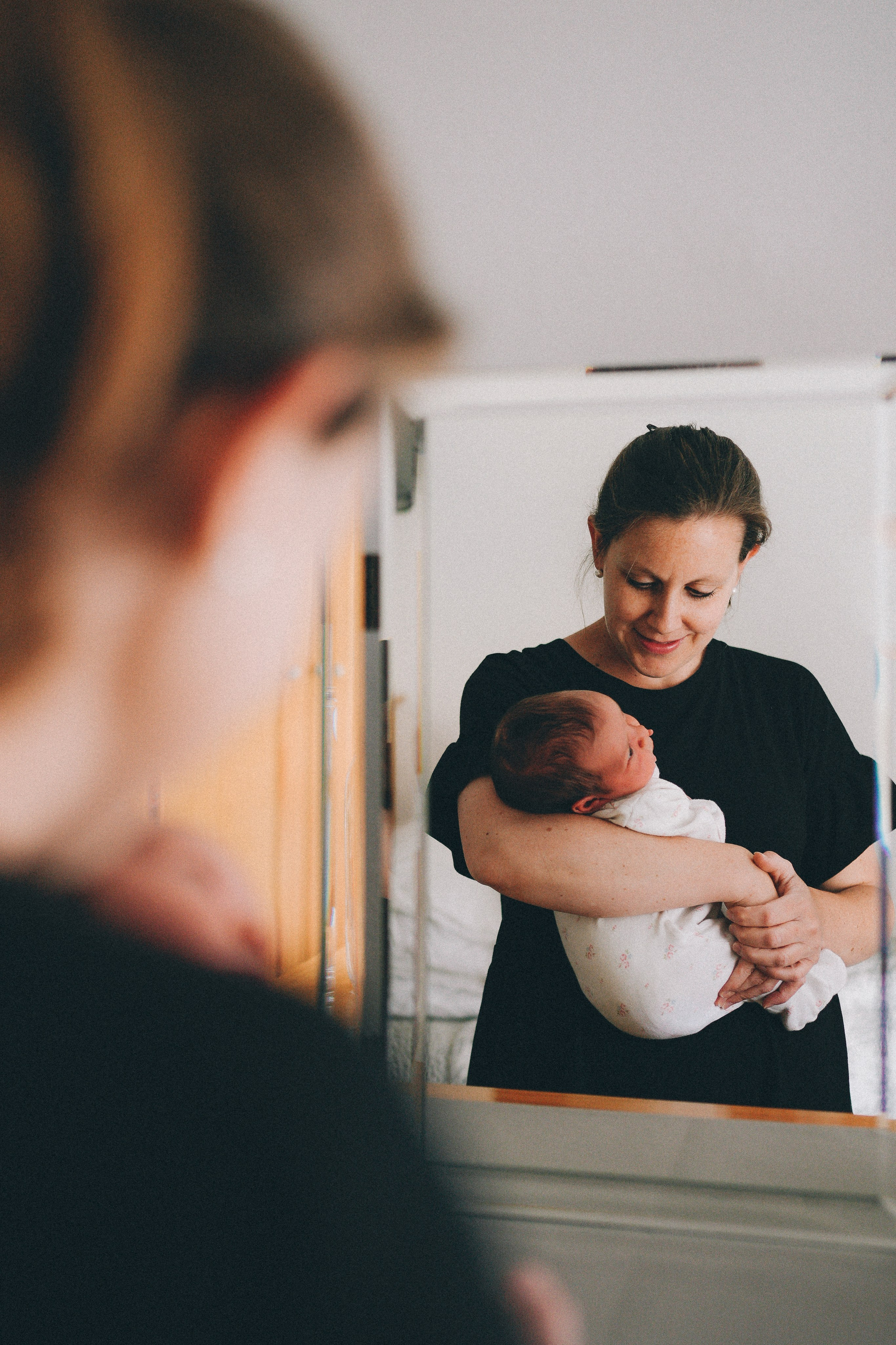 Mum is holding new born baby. Newborn photography in Solihull.