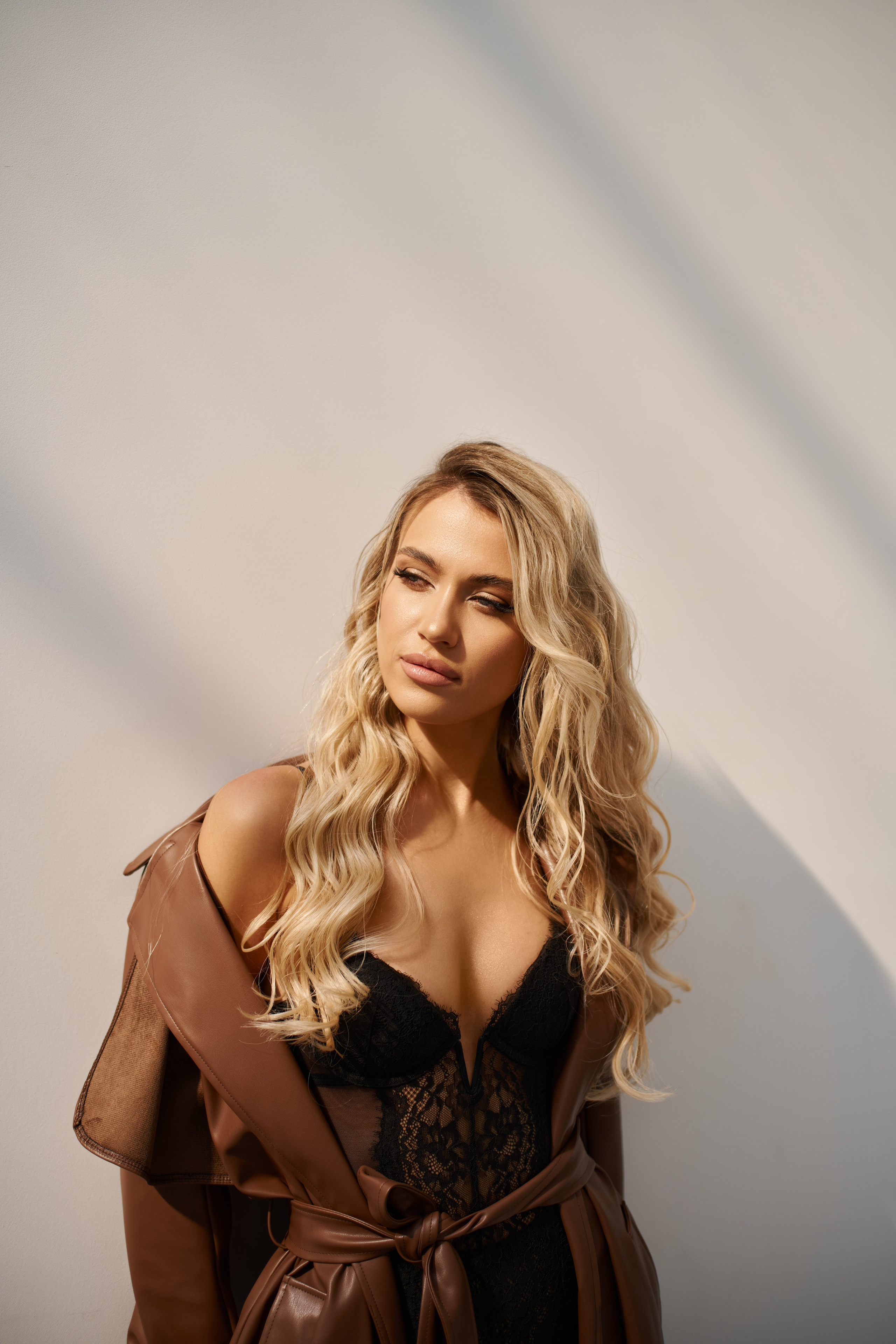 Minimalist fashion portrait of woman in white couture dress with natural daylight studio Warsaw