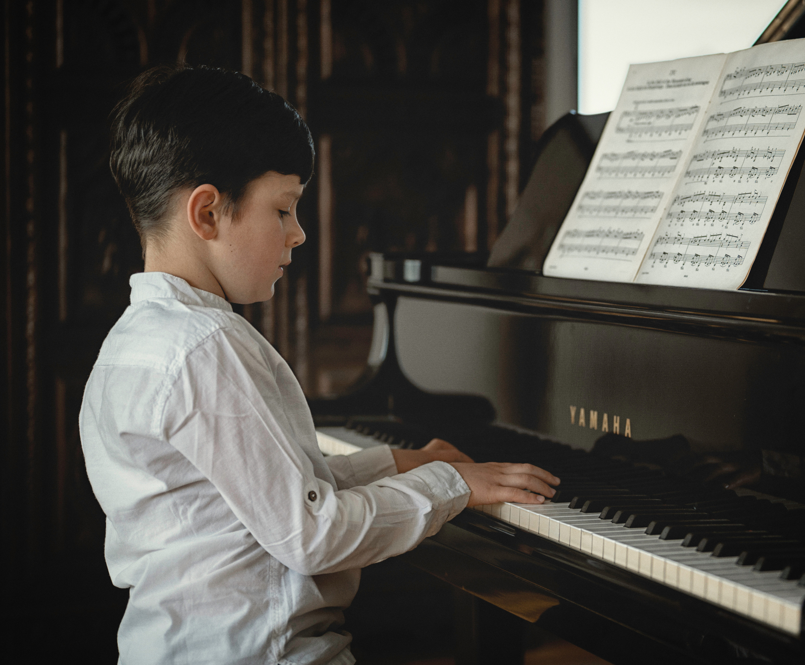 Un garçon joue du piano, absorbé dans la musique