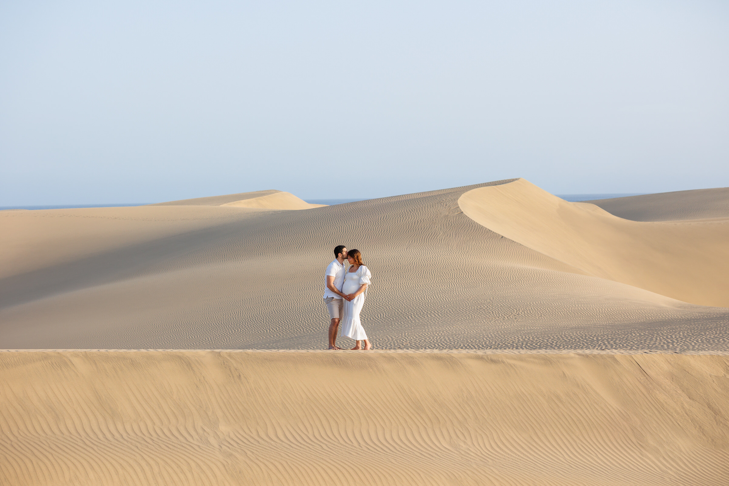 Dunas Maspalomas Photographer captures a couple on a sand dune during a photo shoot.