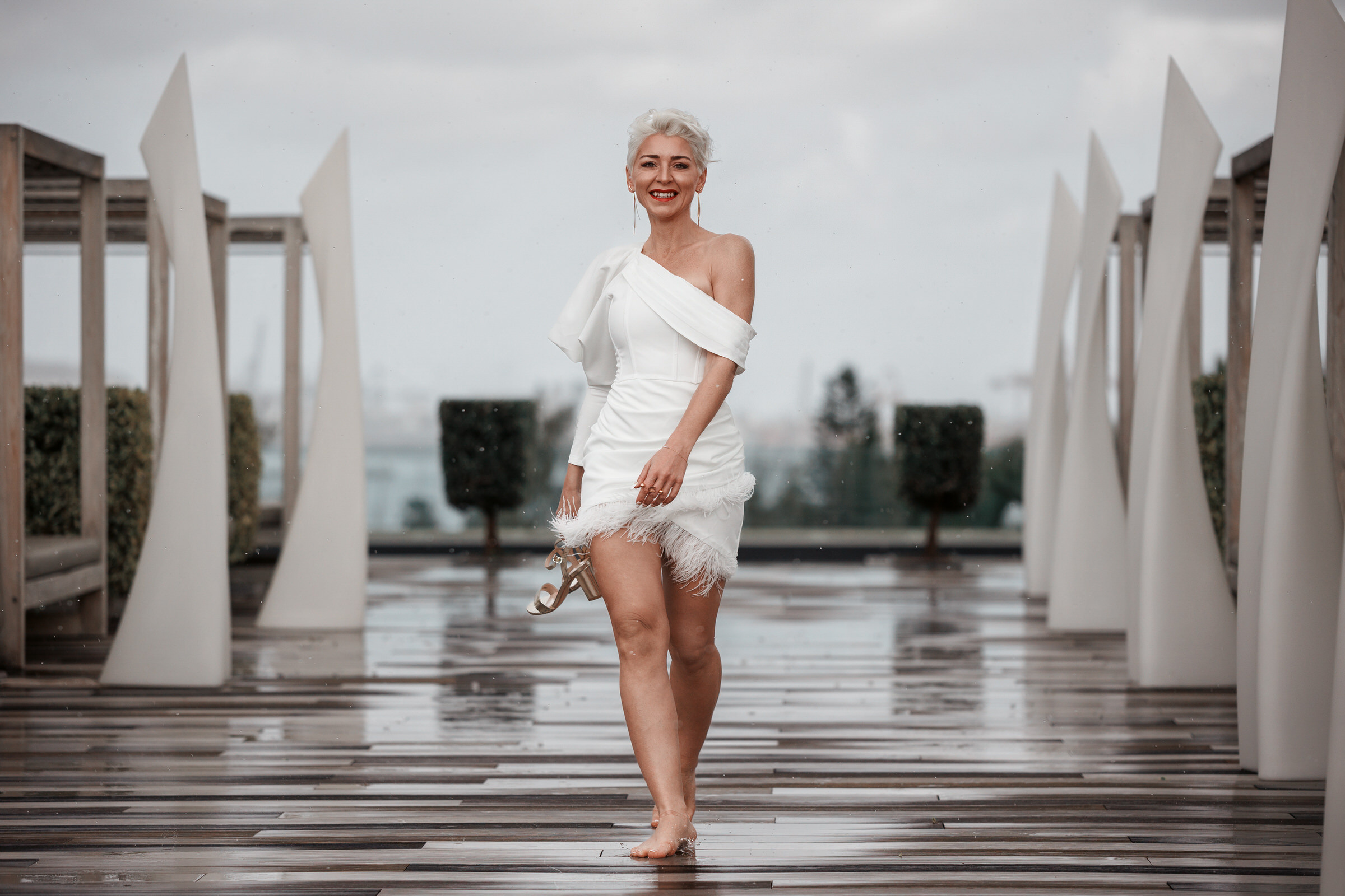 Discover the beauty of an elegant woman in a white dress strolling along the walkway at Hotel Santa Cantalina during a stunning photography session.