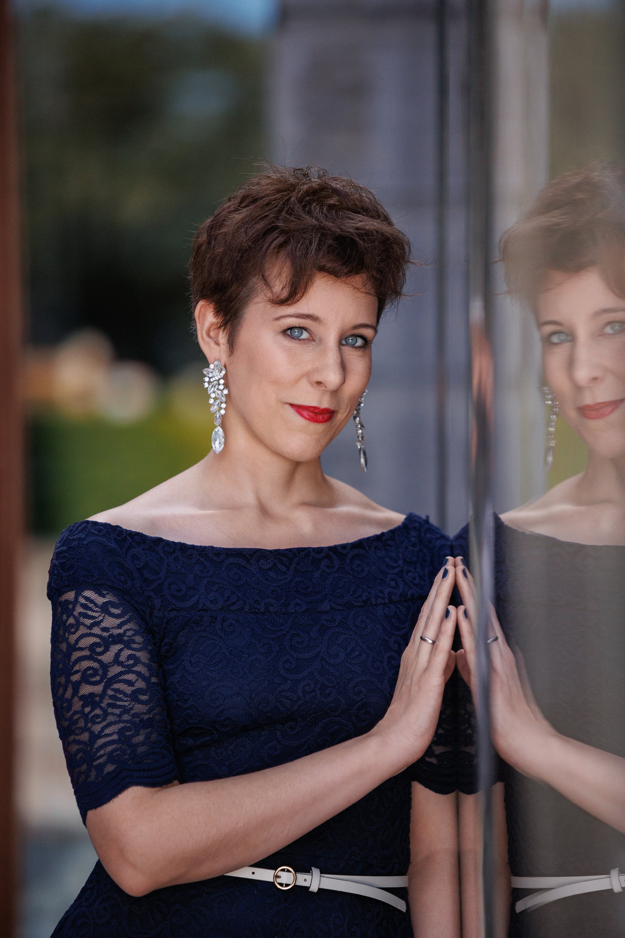 Get inspired by our fashion-forward collection, featuring a woman in a blue dress posing in front of a mirror.