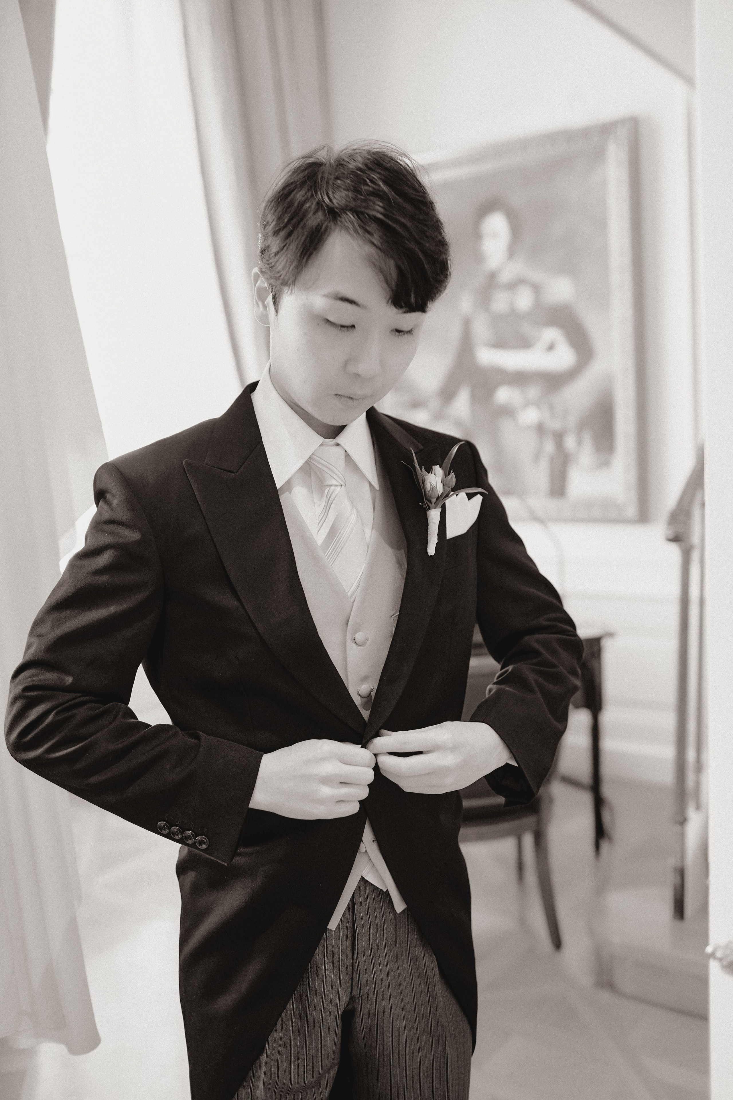 The groom adorns himself with his wedding attire.